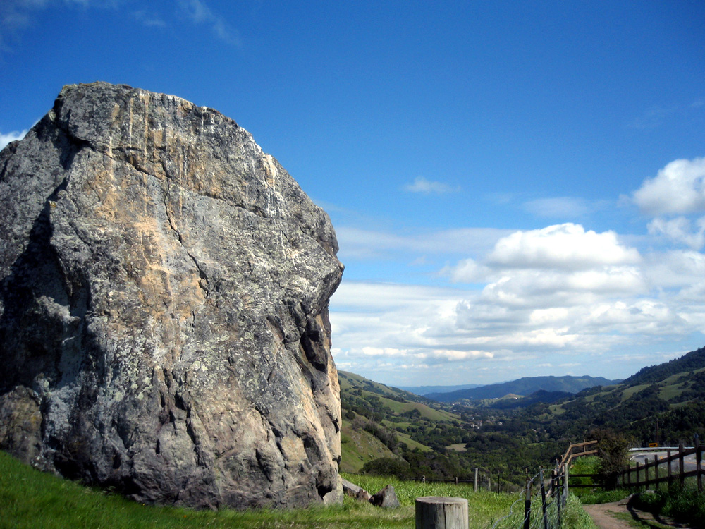 Big Rock, a massive boulder on Big Rock Ridge, with the rolling hills of Lucas Valley spreading out behind it.