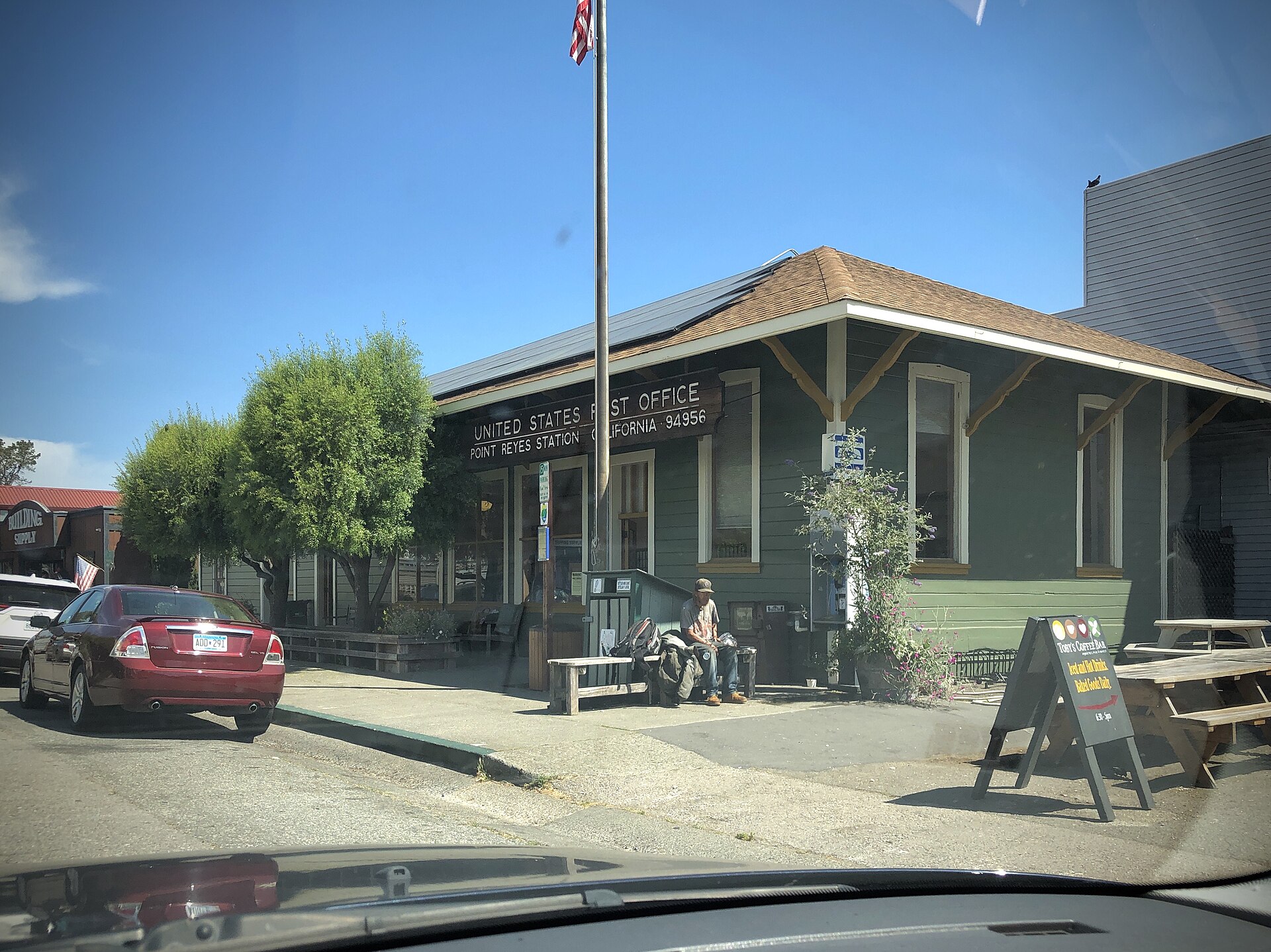 The Point Reyes Station post office, a green wooden building with a 'U.S. Post Office' sign.