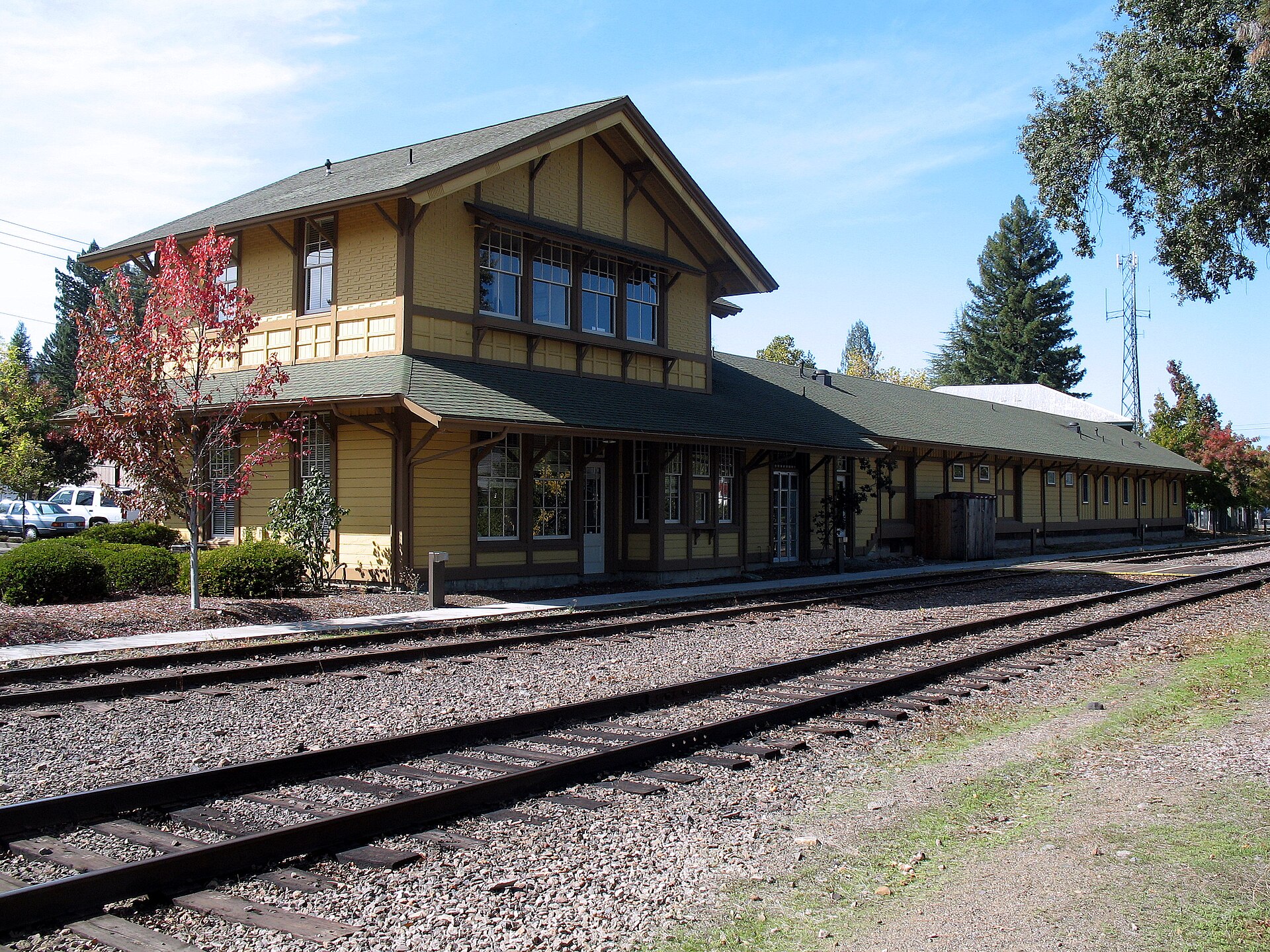 The historic Southern Pacific Railroad depot in St. Helena, a two-story yellow wooden station beside the tracks.