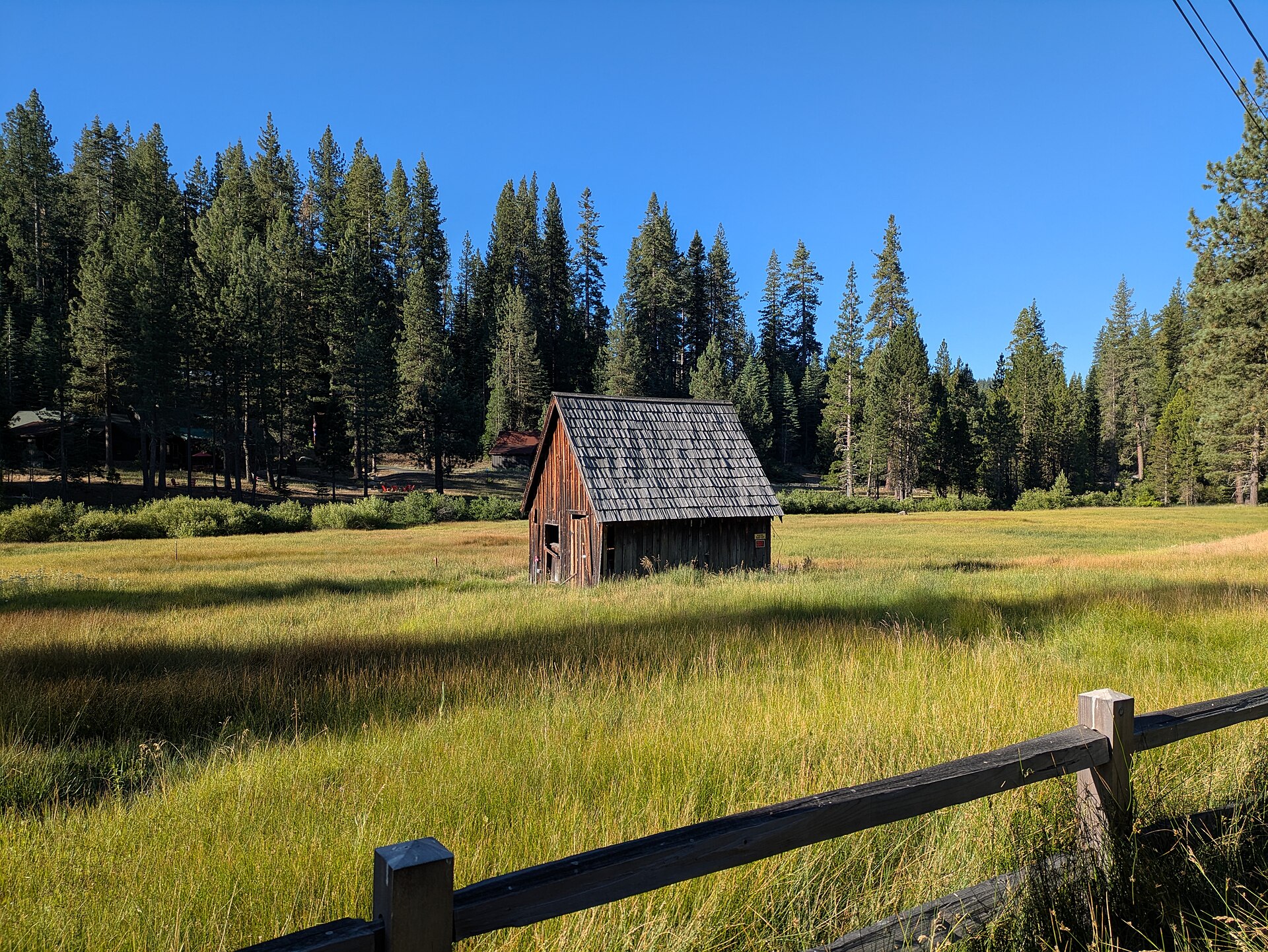 A rustic wooden cabin in a meadow at Strawberry Flat near Strawberry, California.