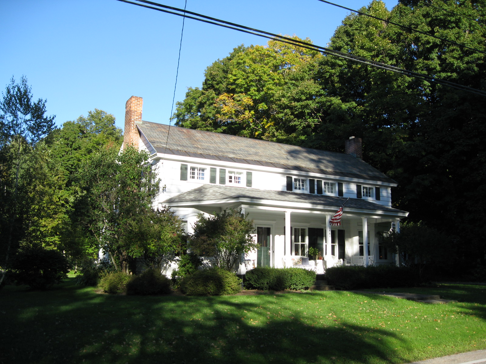 A white colonial house with a columned porch in Dorset, Vermont