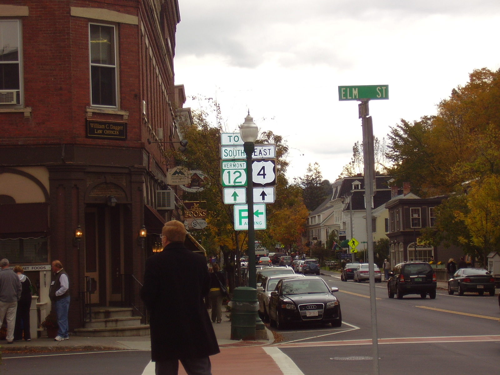 A street with shops and road signs in downtown Woodstock Vermont.