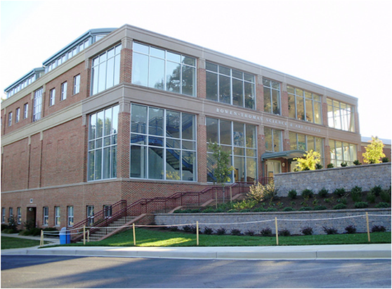 A modern brick and glass school building with landscaped grounds.