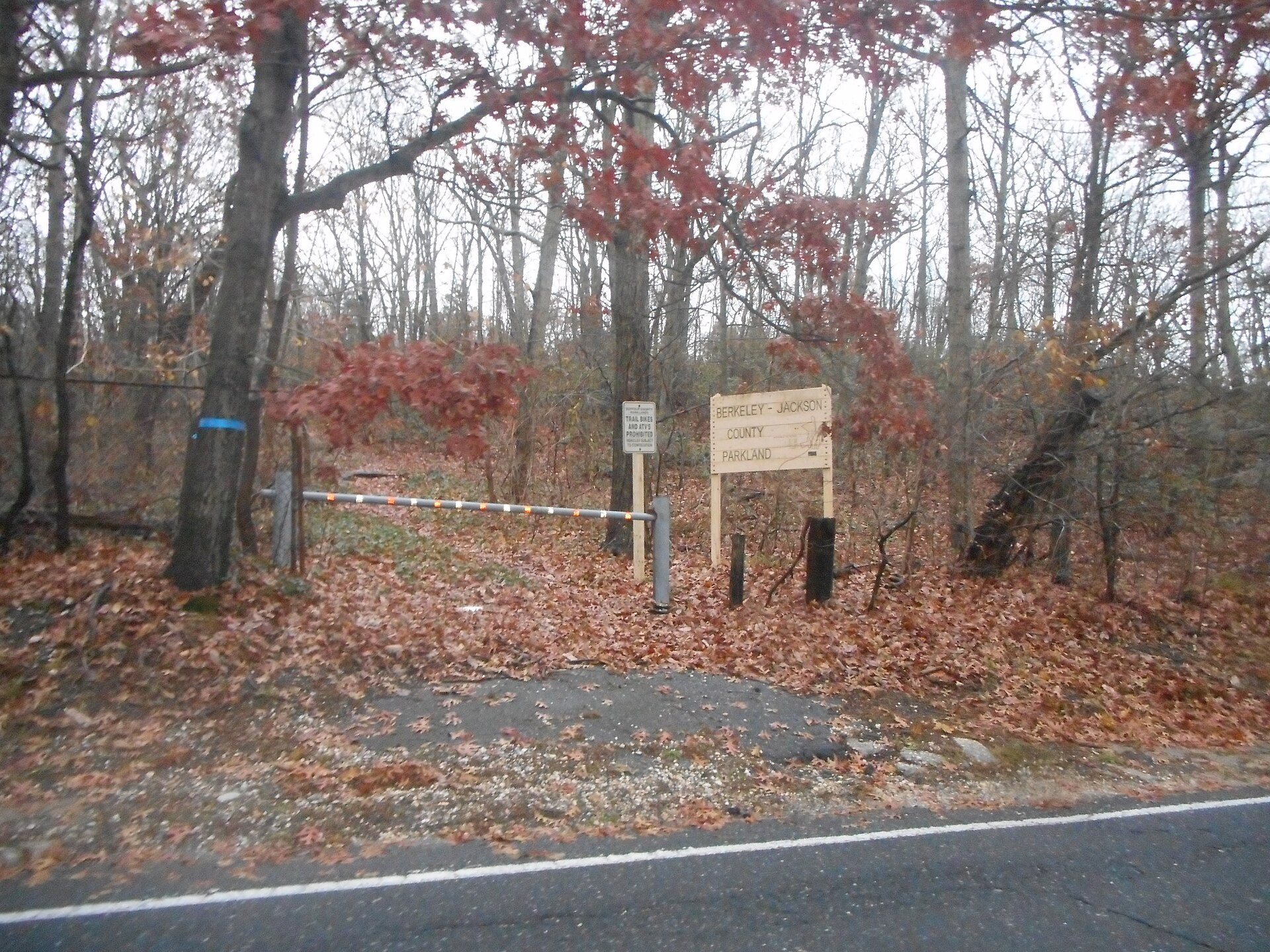A park sign for Berkeley-Jackson County Park among trees in Elwood, New York.