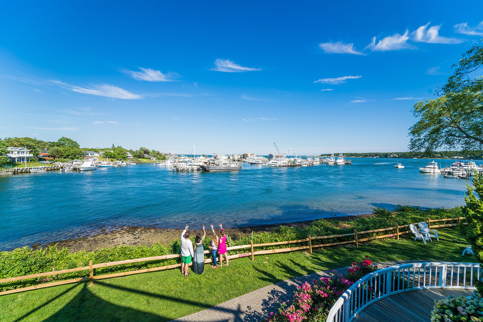 Sailboats and waterfront homes on a sunny day in Hampton Bays, New York.