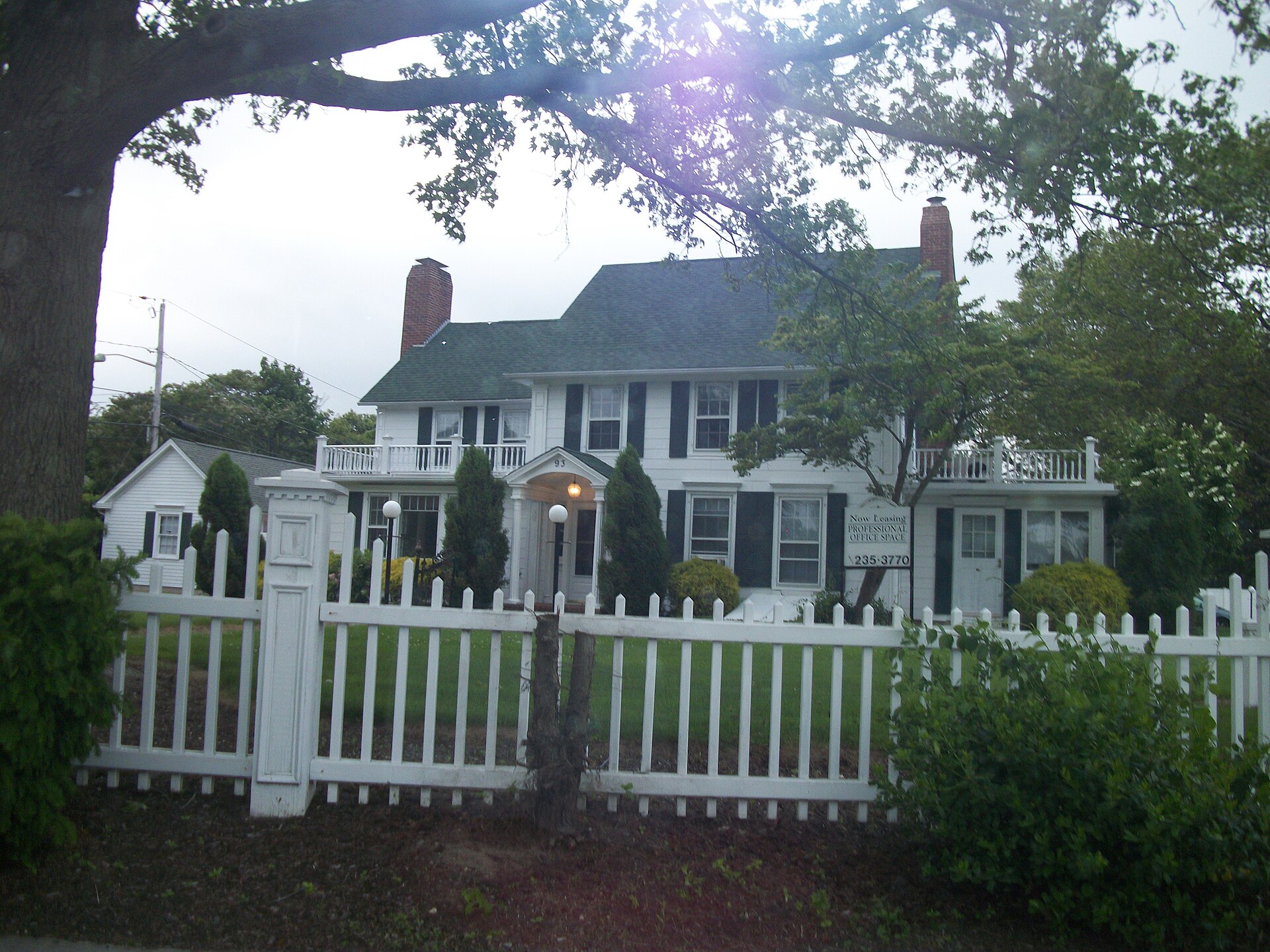 Historic Green House with white picket fence in West Sayville