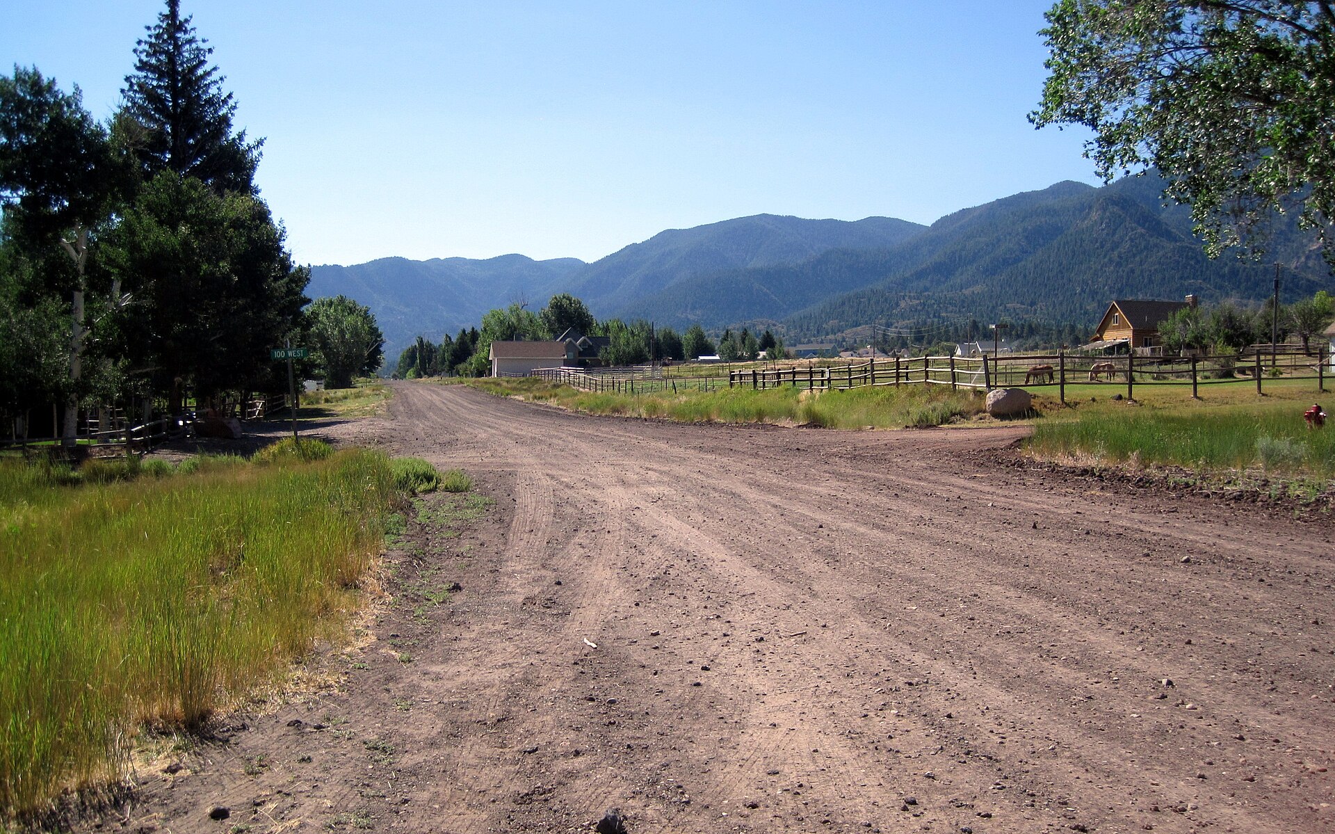 A dirt road through Pine Valley with forested mountains beyond