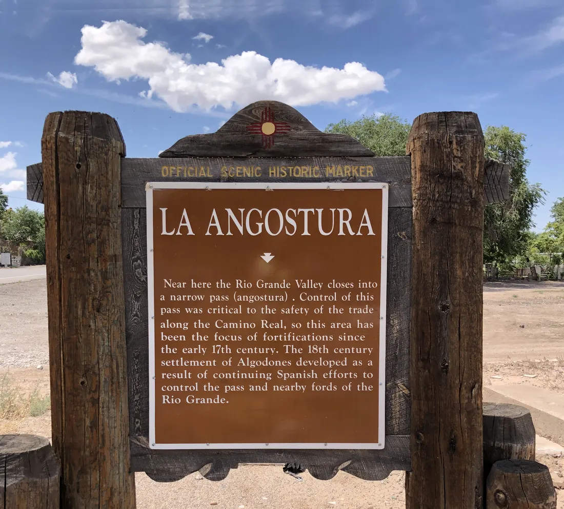 Algodones, New Mexico (La Angostura historical marker). Text reads: Near here the Rio Grande Valley closes into a narrow pass (angostura). Control of this pass was critical to the safety of the trade along the Camino Real, so this area has been the focus of fortifications since the early 17th century. The 18th century settlement of Algodones developed as a result of continuing Spanish efforts to control the pass and nearby fords of the Rio Grande.