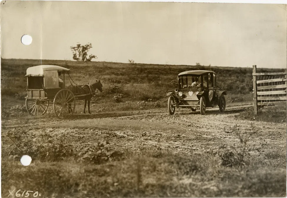 A Flanders electric car passing a horse-drawn wagon on a rural dirt road at Darrow during the 1912 Glidden Tour pathfinding expedition