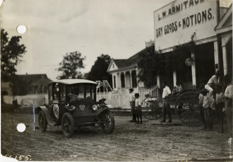Flanders electric car at Darrow, Louisiana, during the 1912 Glidden Tour pathfinding expedition; onlookers in front of the L.W. Armitage dry goods store