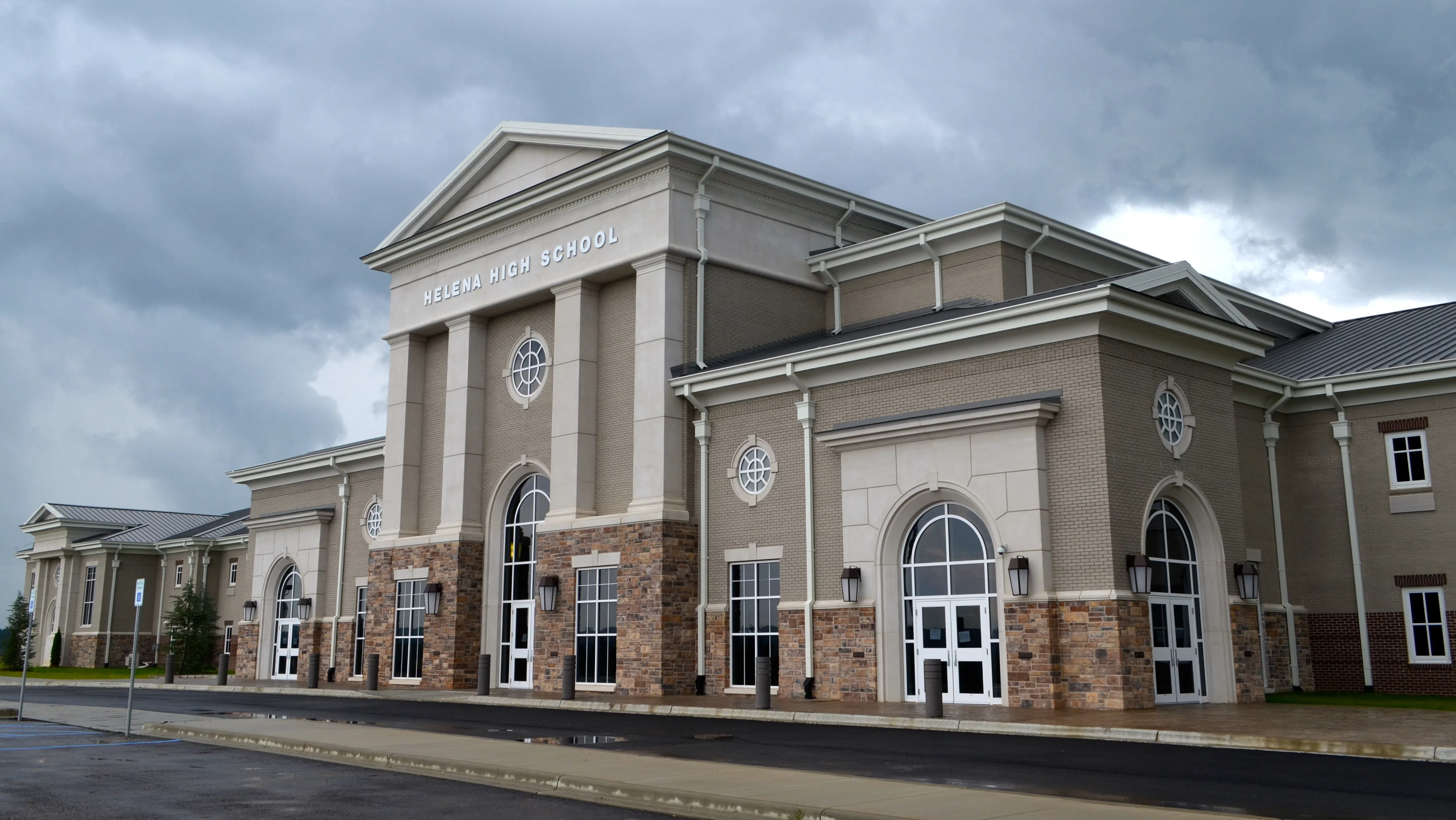 This is a photo of the front of Helena High School in Helena, Ala., including its main entrance and a small portion of its front parking lot. This is the west side of the school