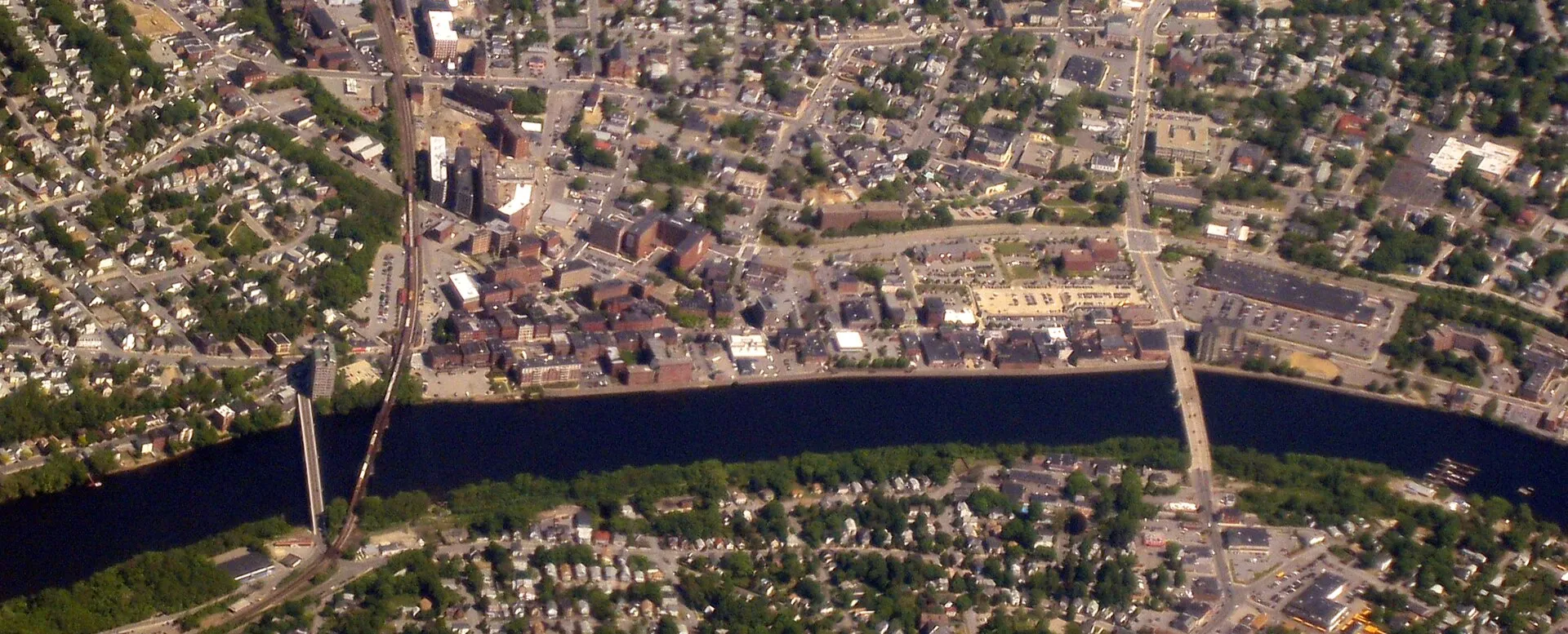 Downtown Haverhill, Massachusetts, with Bradford on the near side of the Merrimack River. The bridge on the right is South Main Street. On the left is the Gozelian Bridge.