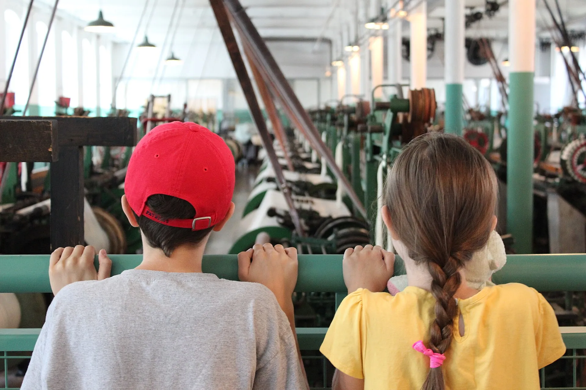 The next generation of park visitors watching as 88 historic looms weave cotton cloth at Lowell National Historical Park
