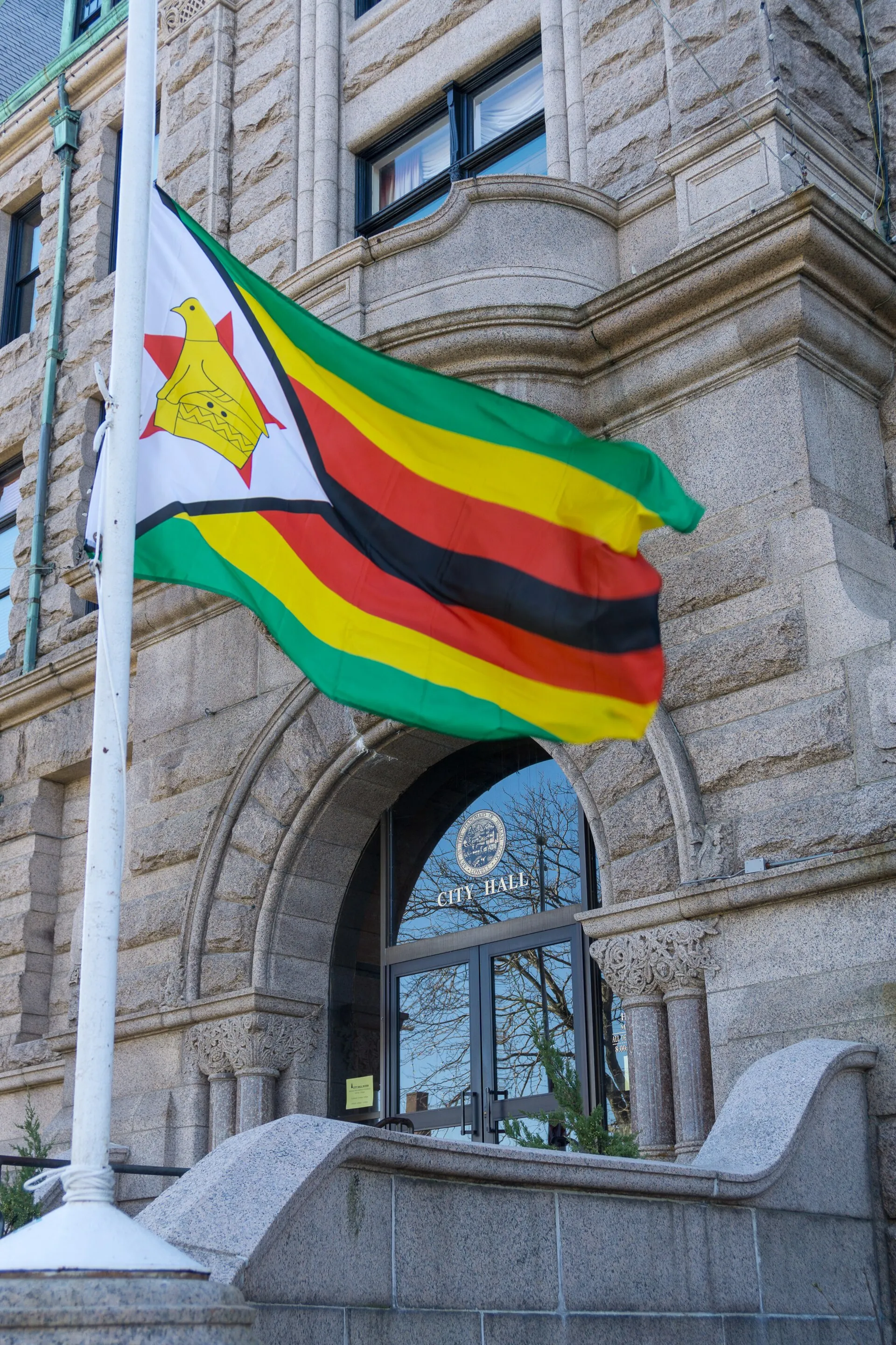 Flag of Zimbabwe flies in front of City Hall, Lowell, Massachusetts