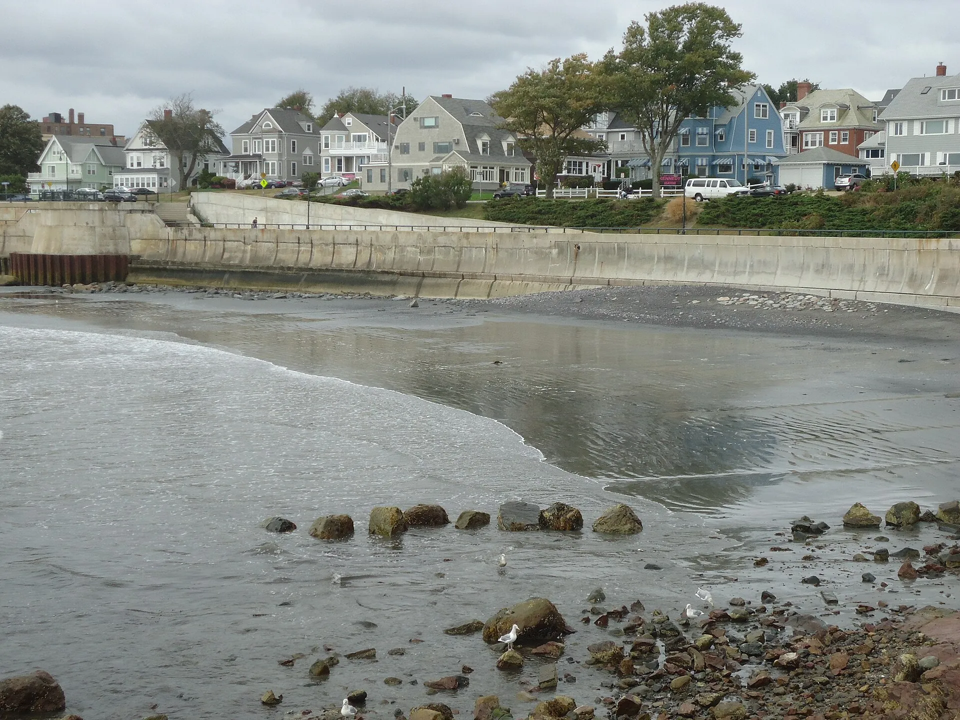 Looking southeast at houses, beach, rocks, at Lynn, Massachusetts, from Red Rock Park on the Atlantic Ocean.