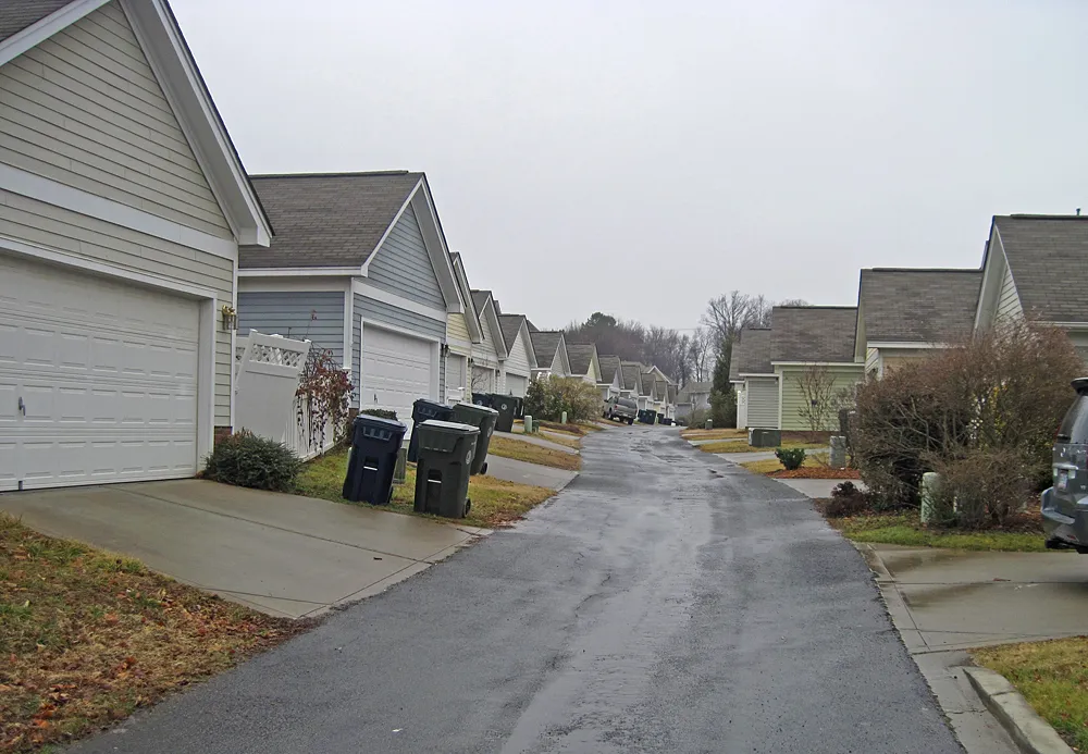 This alley in Birkdale Village has the garages setback from the alleyway. This extended right of way is necessary to accomodate utility easements--note the green utility service bollards on the...
