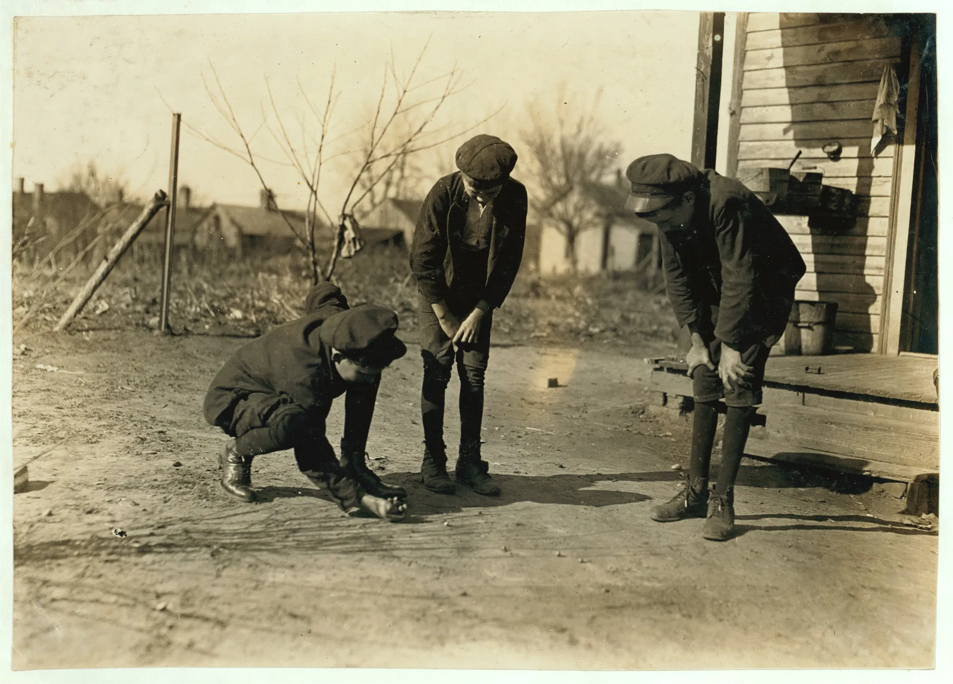 Title: Brantley Henson (boy near porch). Been in mill 8 years. Jasper Henson, (in middle) Been in 3 years. Thedie Miller (Shooting). Been in 3 years. All doffers. Salisbury Cotton Mills, (N.C.)...