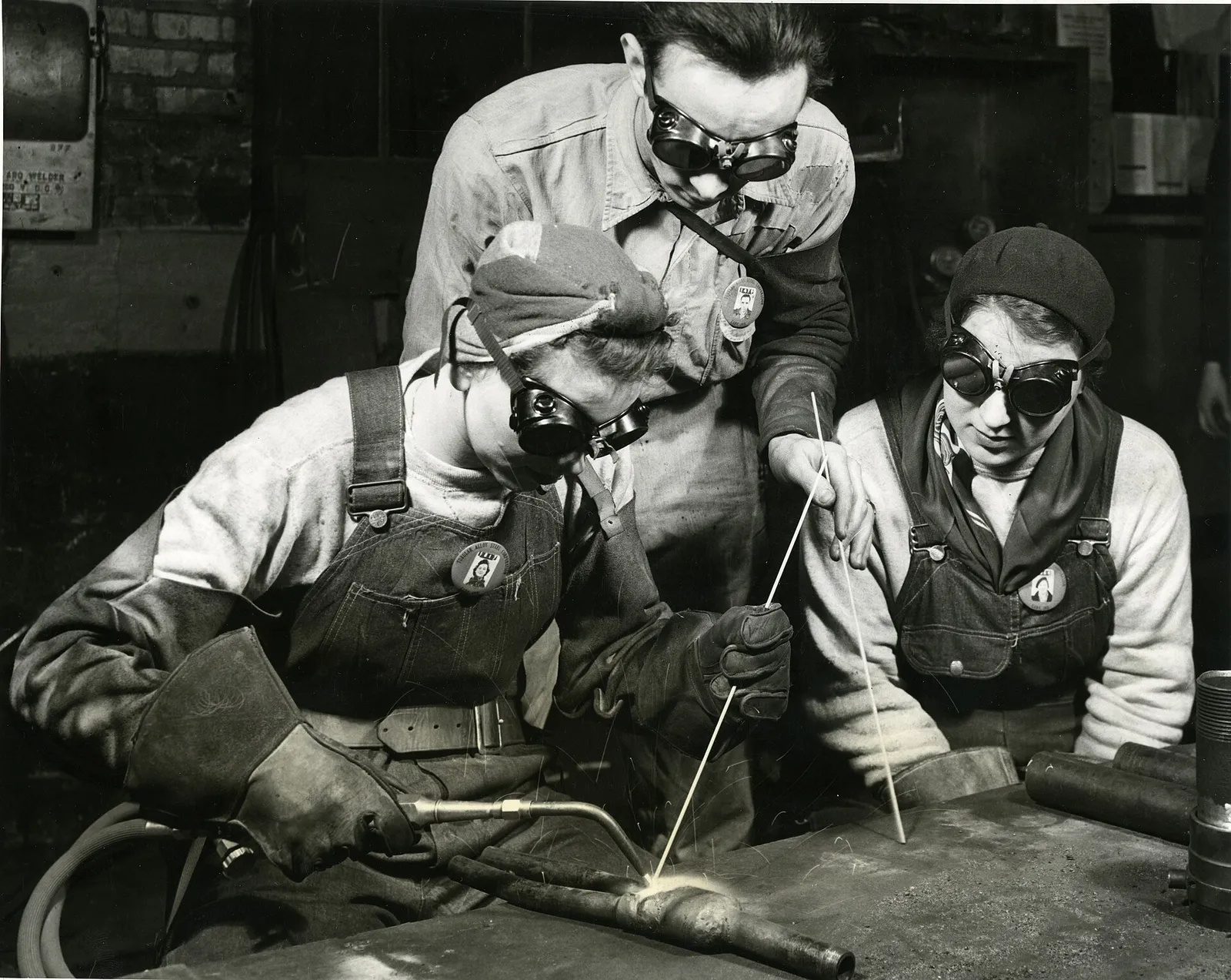 General notes: Peggy Bridgeman at the left demonstrates to Ruth Harris the correct technique while their instructor, Lee Fiscus, looks on attentively, in the Gary plant of the Tubular Alloy Steel Corporation, United States Steel Corporation subsidiary. Peggy is acclaimed by her superiors to be one o