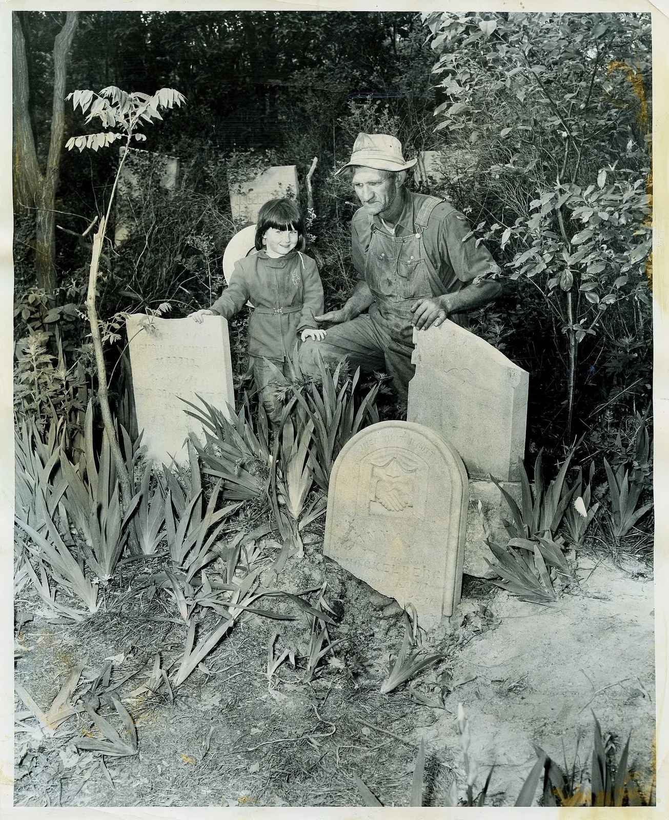 Date: May 26, 1954 Source Type: Photograph Publisher, Printer, Photographer: Charles C. Smith for the Chicago Sun Times Postmark: Not Applicable Collection: Steven R. Shook Remark: Photograph of Walter Schrock, 54, whose farm embraced James Cemetery, and Lou Ellen Jacobs, 4, Schrock's neighbor, exam