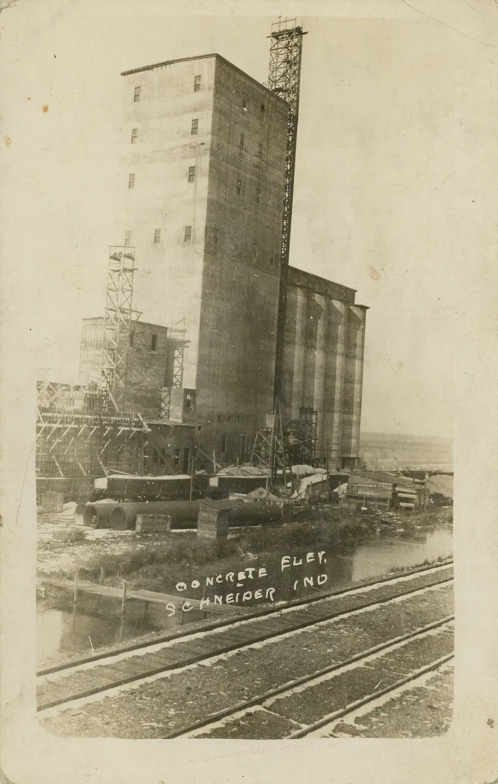 CONCRETE ELEV. SCHNEIDER IND Date: 1913 Source Type: Postcard Publisher, Printer, Photographer: Unknown Postmark: March ??, 1913, Schneider, Indiana Collection: Steven R. Shook Remark: This enormous concrete elevator was later expanded and still stands today [2022], though it is abandoned and no lon