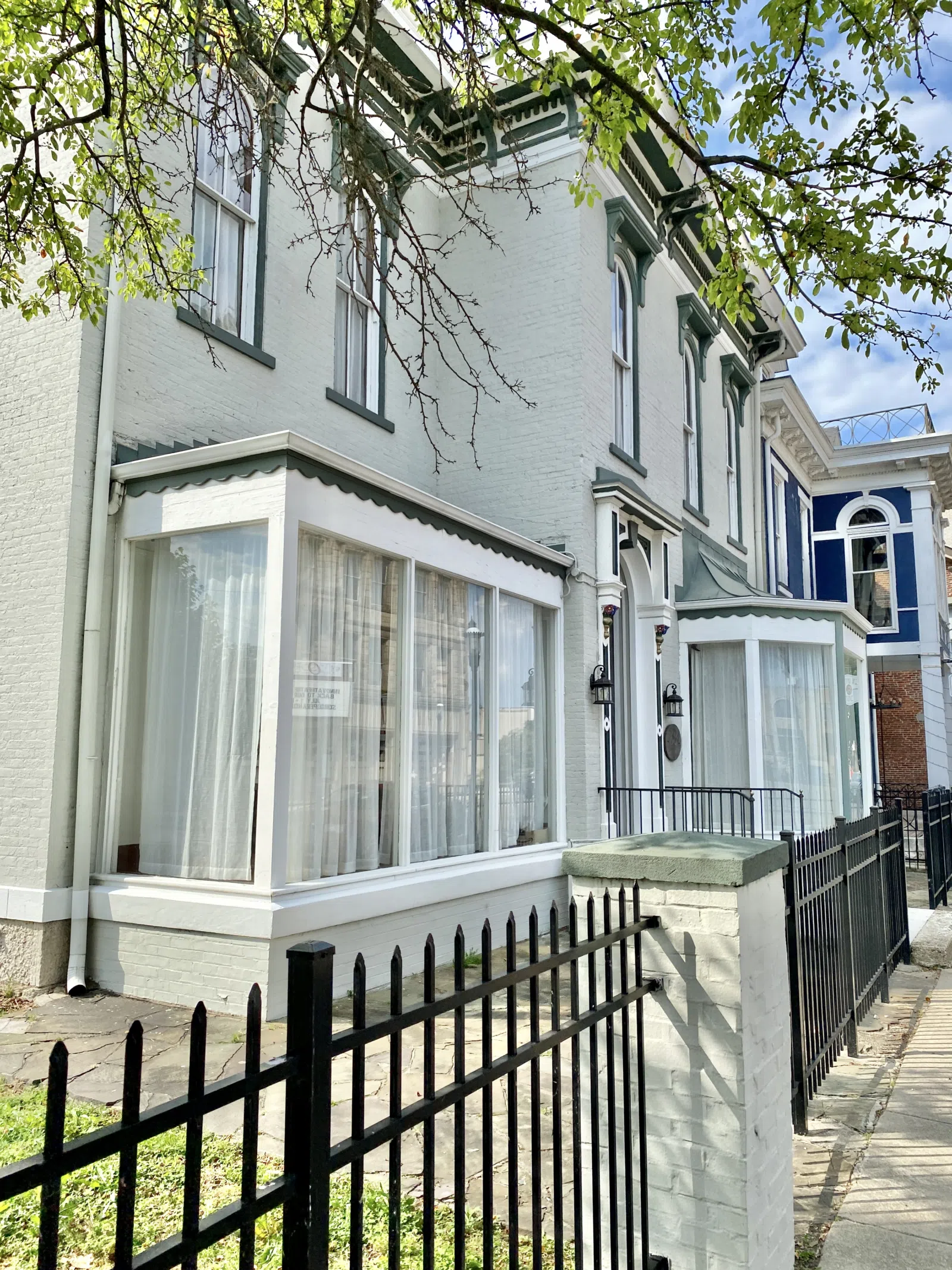 Built in 1870, this Italianate-style house was constructed for George Barnitz, a local businessman. The building features a painted brick exterior, two-over-two double-hung windows with decorative hoods, a cornice with b