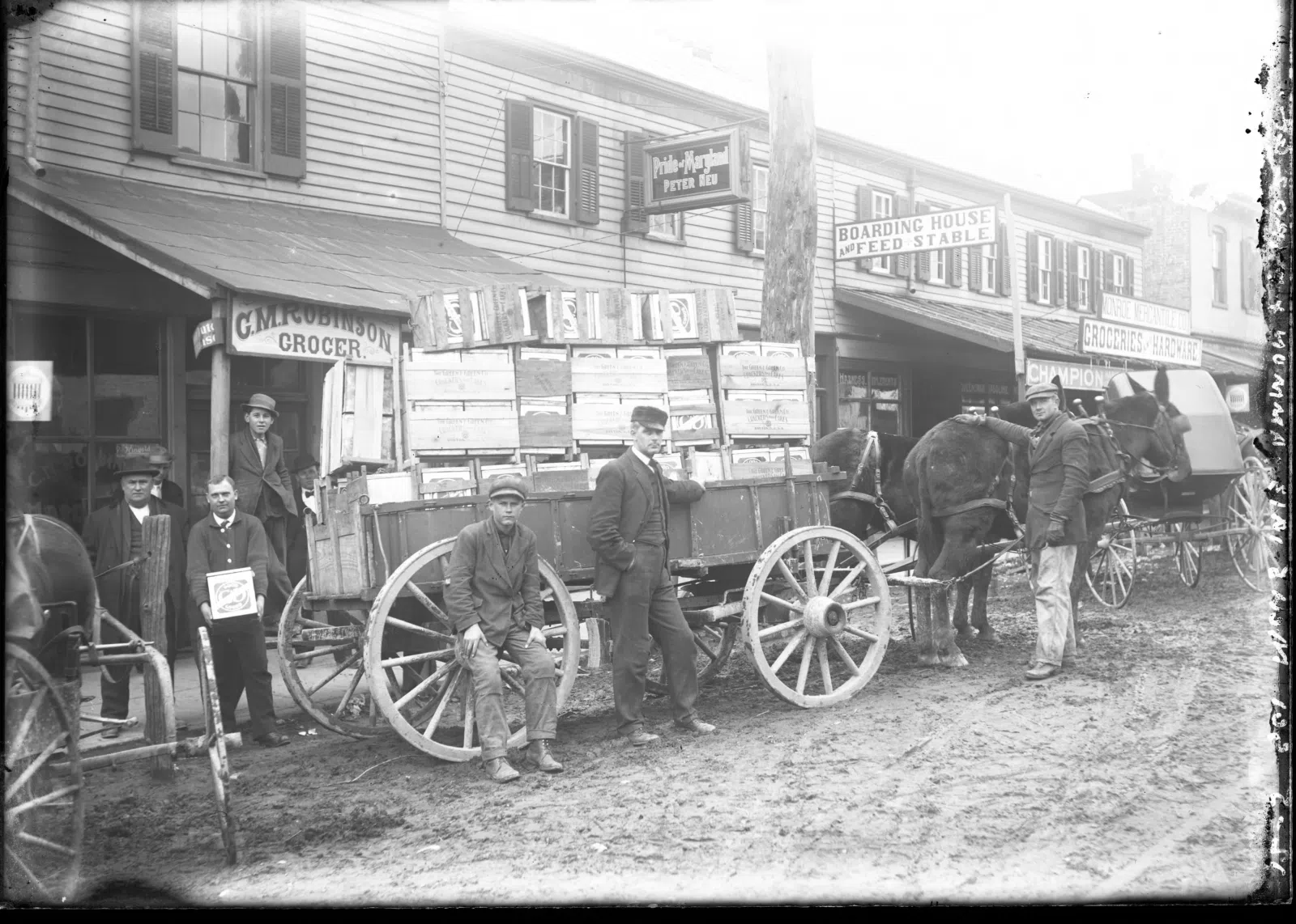 The businesses pictured in these two photographs are: C. M. Robinson Groceries and Hardware; Pride of Maryland, Peter Neu; Boarding House and Feed Stable; and Monroe Mercantile Company. The businesses are on Pike Street
