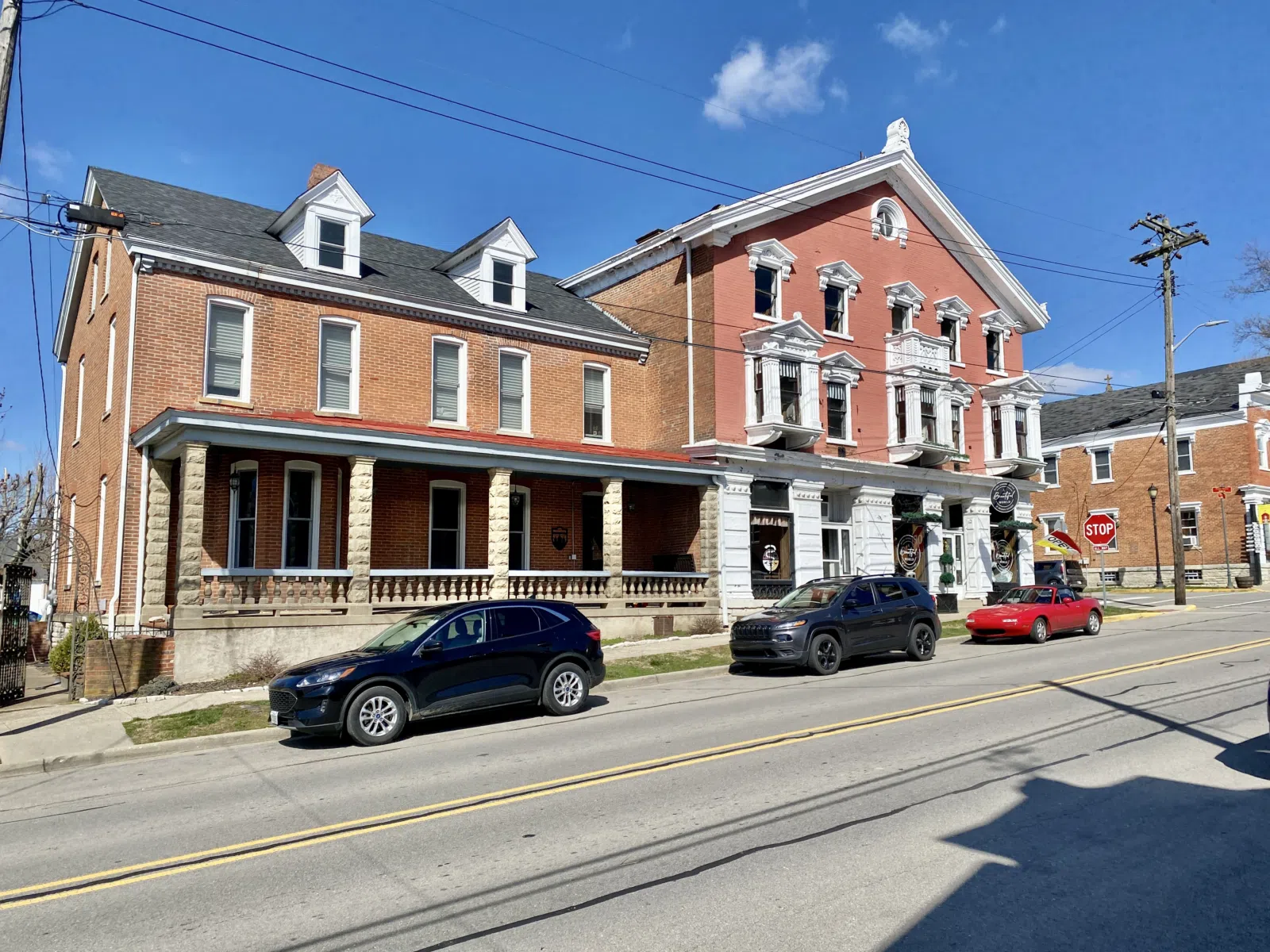 Built in 1897, this Queen Anne-style house was constructed for August A. Hackman, who owned the adjacent store. The house features a red brick exterior, side-gable roof, one-story bay window at the west end of the first