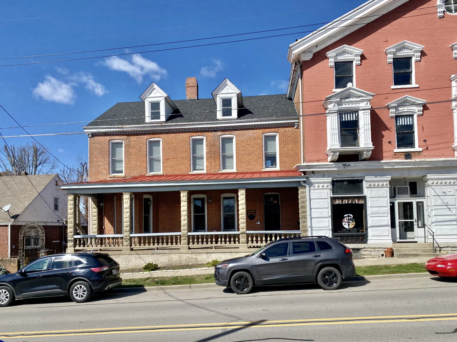 Built in 1897, this Queen Anne-style house was constructed for August A. Hackman, who owned the adjacent store. The house features a red brick exterior, side-gable roof, one-story bay window at the west end of the first