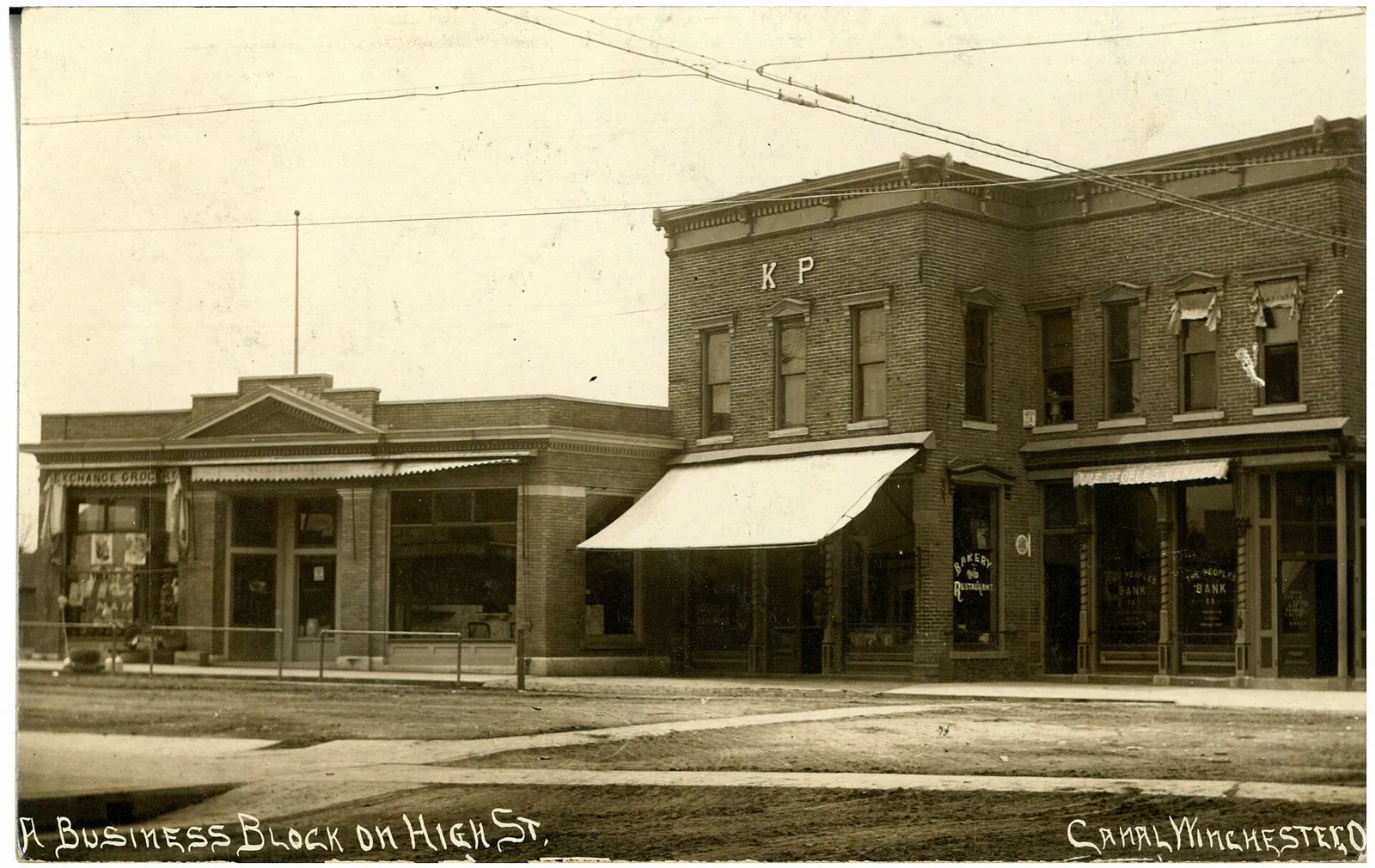 Black and white photograph showing a business block, circa 1909.