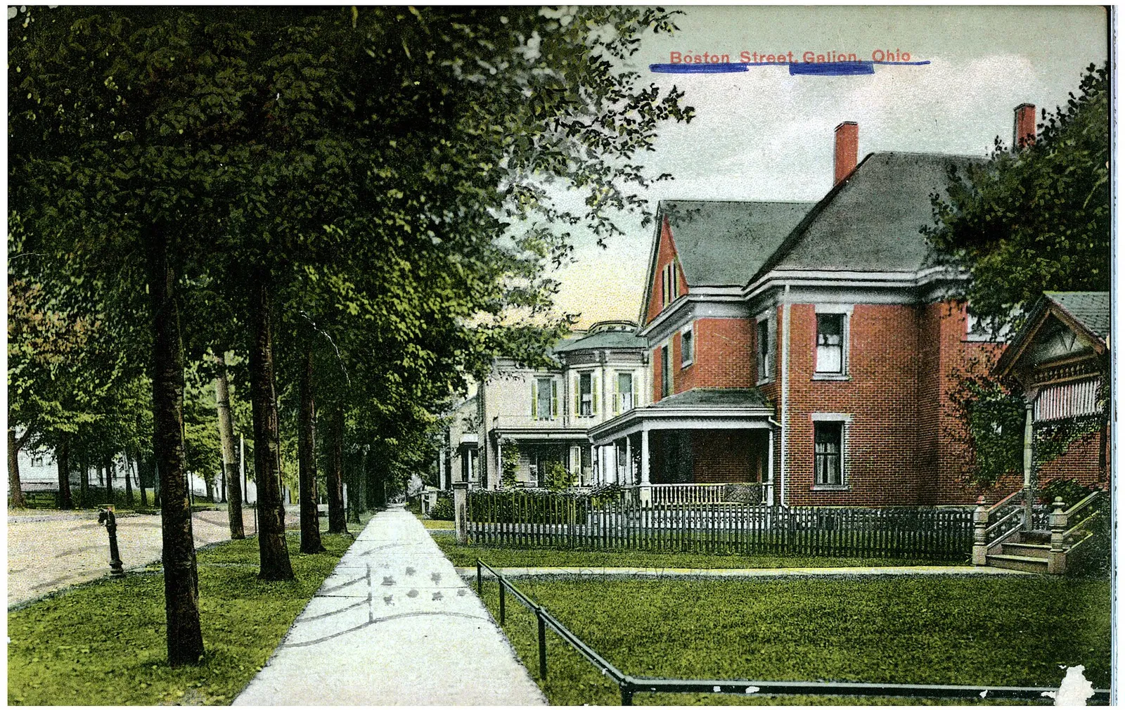 A view of houses along a tree lined street.