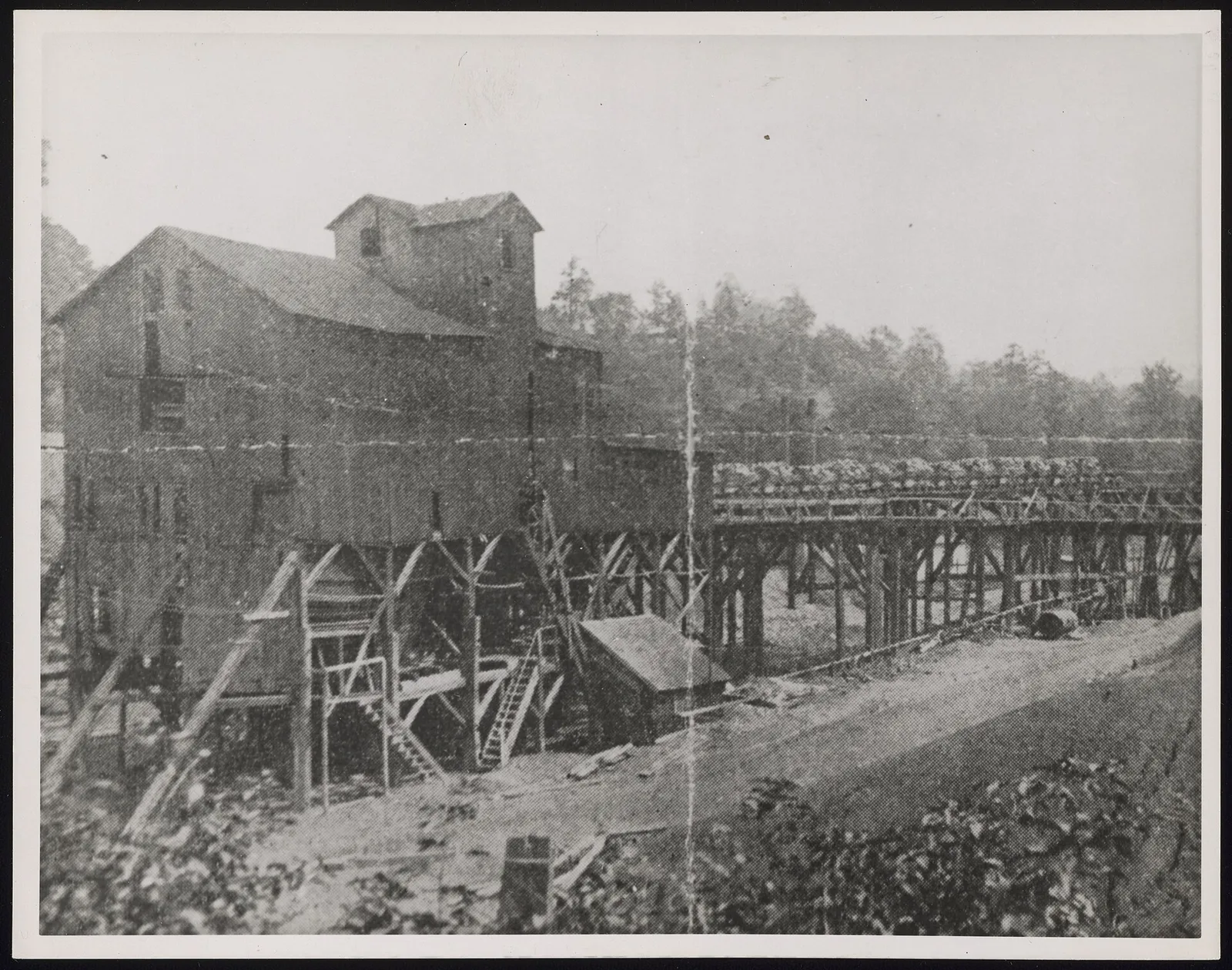 circa 1890-1922Tipple of E.C. Jenkins XX Mine. The tipple occupies the left area of the image. A trestle for transporting mine carts extends from the tipple at