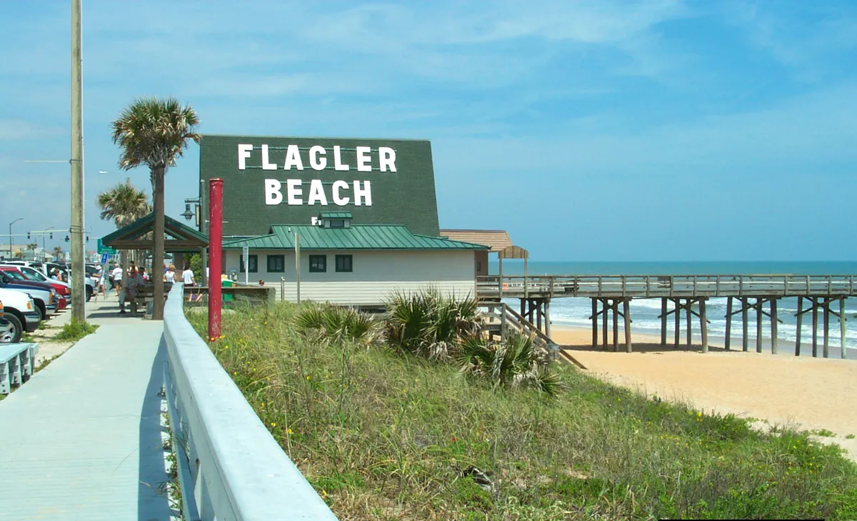 Large Hollywood-style white letters on the side of a beach house announce the location of the Flagler Beach Pier.