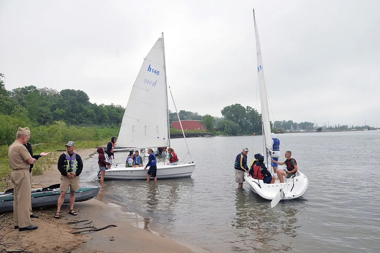 Rear Adm. Clifford S. Sharpe, commander of Naval Service Training Command, observes Navy Junior ROTC cadets preparing sailboats for a sailing course on Lake Michigan at the NJROTC Leadership Academy here June 17. The cad