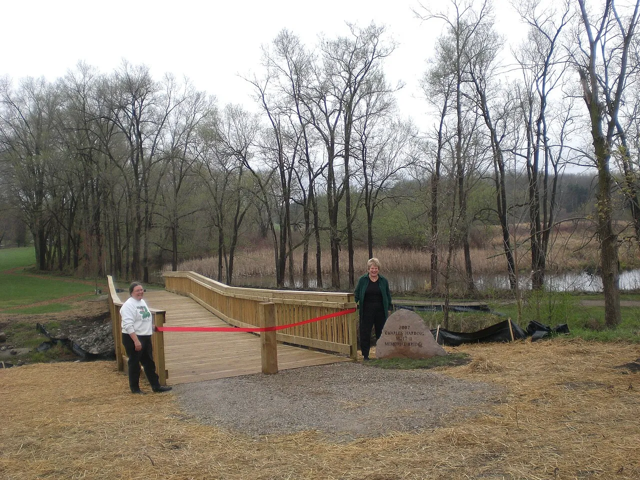 HeadWatersTrails Inc built this Water Heritage Trail memorial bridge at WaterWorks Park in Holly, Michigan. It spans the Shiawassee River near the historic Holly Waterworks building with an 1869 horizontal water wheel.