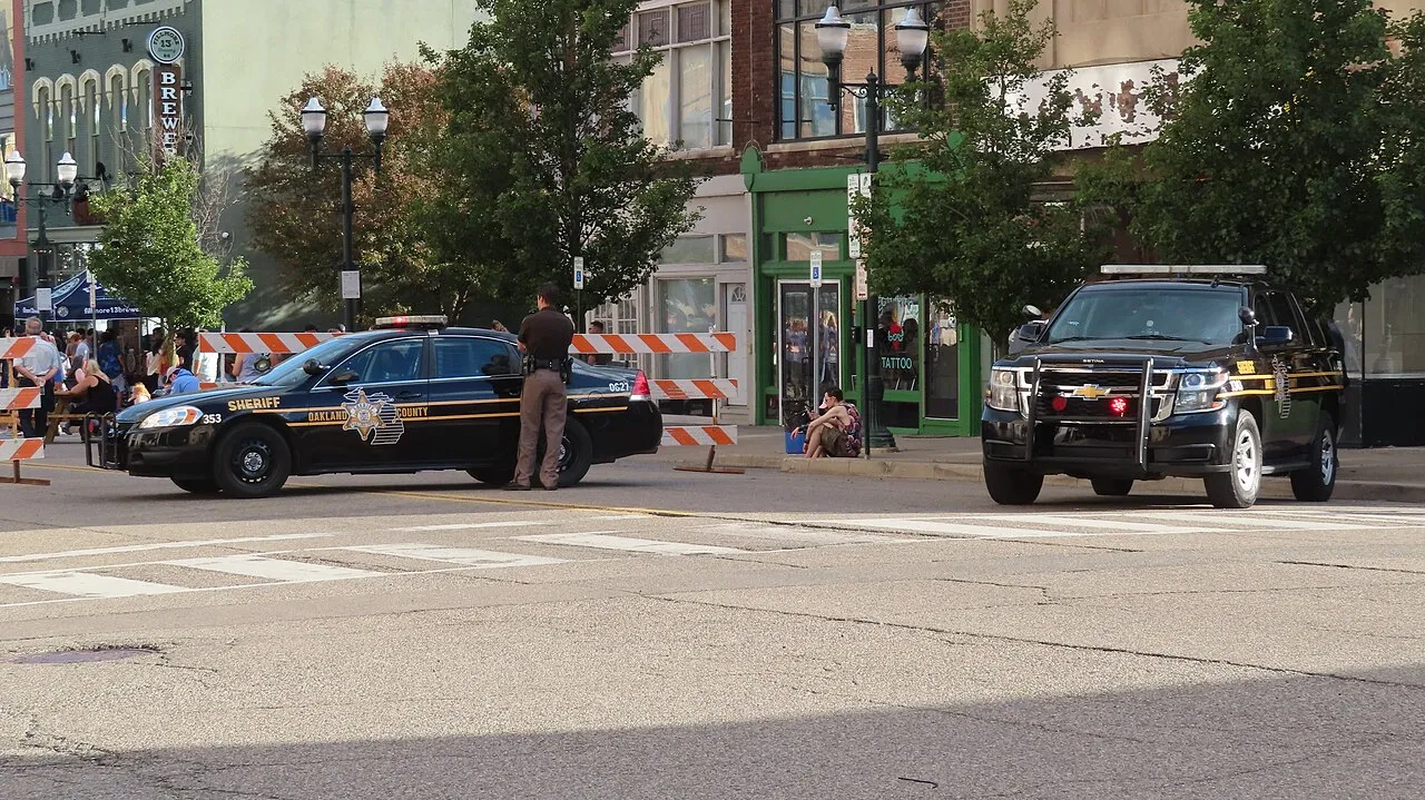 Oakland County Sheriff's Office deputy and patrol cars, seen in downtown Pontiac, Michigan.