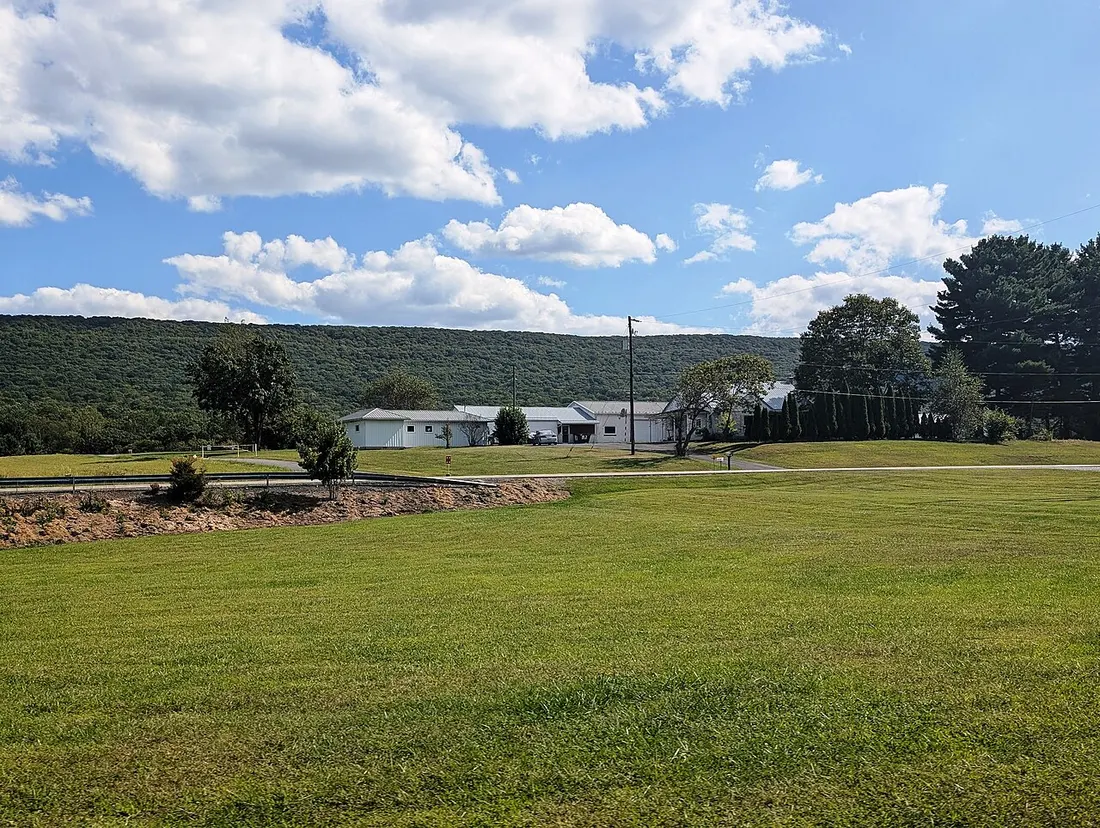 Photo of buildings at the east end of Bendigo Airport in Rush Township, Dauphin County, Pennsylvania. Photo taken from Reiners School Road looking south-southeast across Pennsylvania Route 325 (Clarks Valley Road).