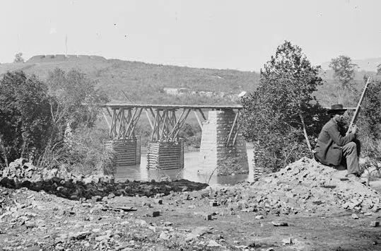 Detail of the George N. Barnard photograph of the railroad bridge over the Holston River at Strawberry Plains, with a Union sentry and a fort in the distance
