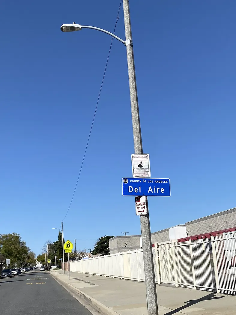 The Del Aire neighborhood sign on a street in the community.