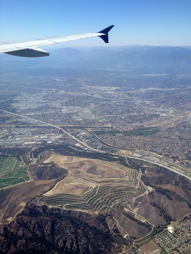 Aerial view of the terraced Puente Hills Landfill and the City of Industry below
