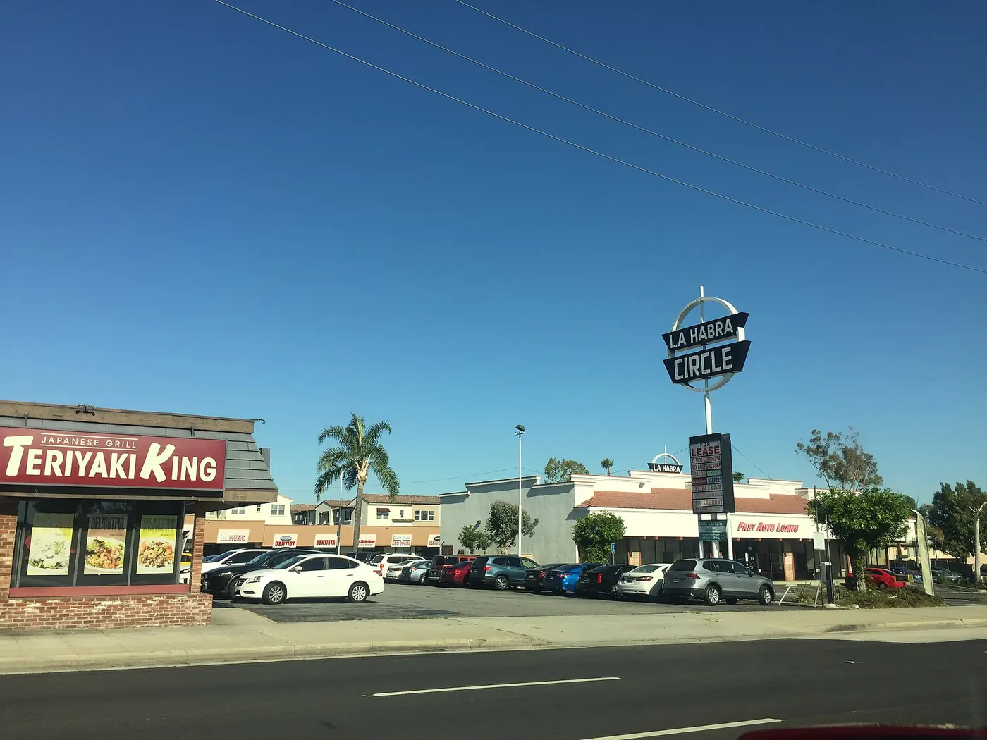 La Habra Circle Shopping Center at 1925 W La Habra Blvd, La Habra, California. La Habra Circle was built in 1959 and features a Googie/mid-century modern sign. View from the southbound lane of North.