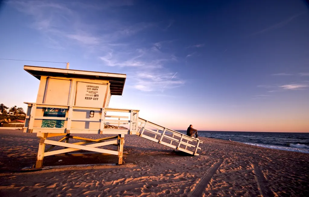 A lifeguard tower on Malibu Beach at sunset.