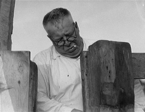 Dorothea Lange May 1937 photo of Henry Lotz closing the gate to the barns at the Midway City Dairy Association, a cooperative in Midway City, California, United States. Seven families having nine men.