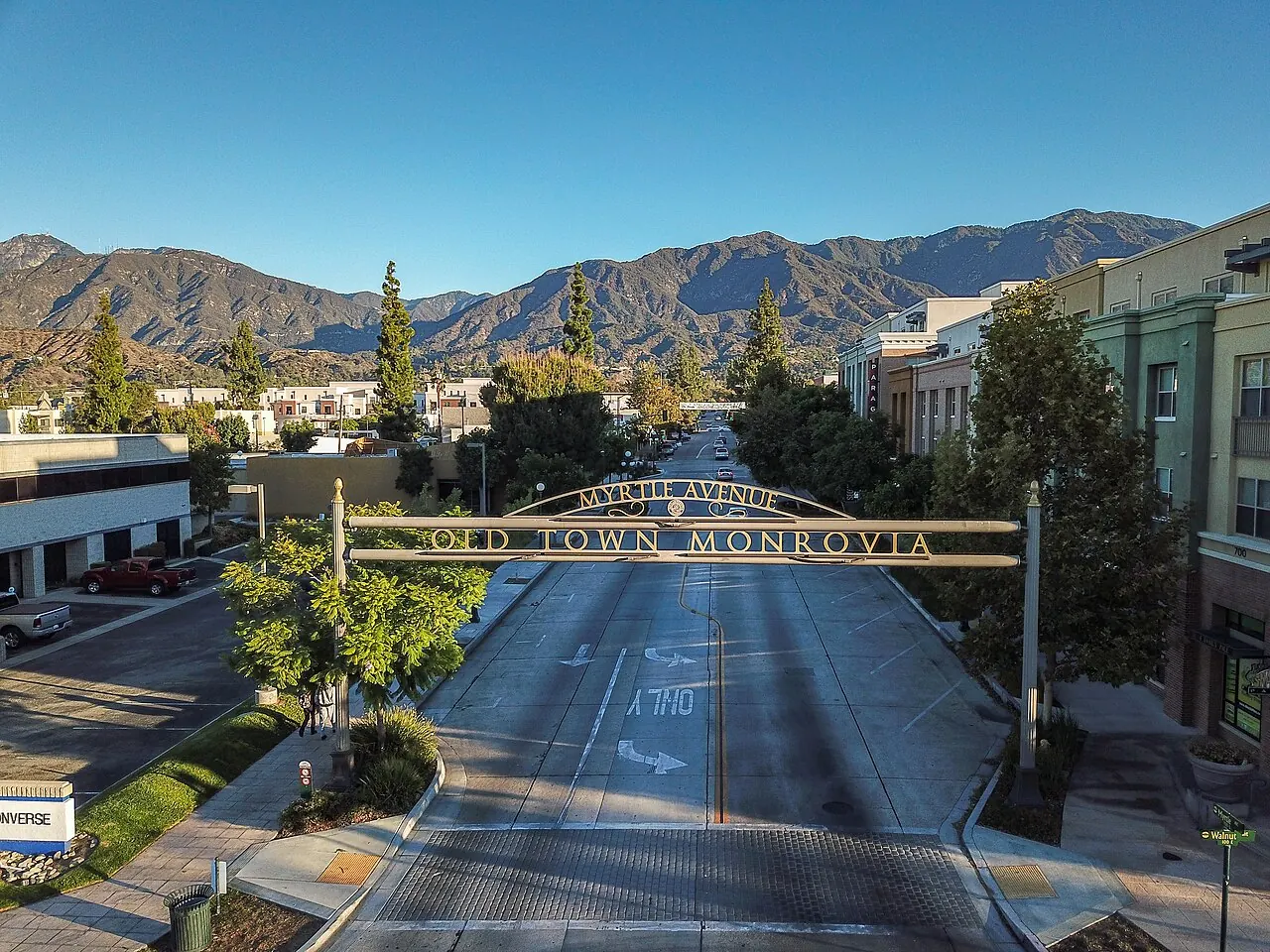 Aerial view of the Old Town Monrovia arch over Myrtle Avenue, with the San Gabriel Mountains behind.