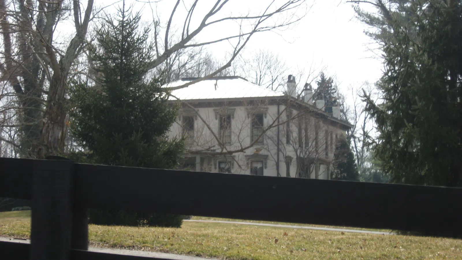 Eastern side and northern front of the James Trigg House, located on the southern side of Boy Scout Road (Kentucky Route 329) in Prospect, Kentucky, United States. Built in 1865, it is listed on the National Register of Historic Places. The fence in the foreground was the unfortunate result of heavy