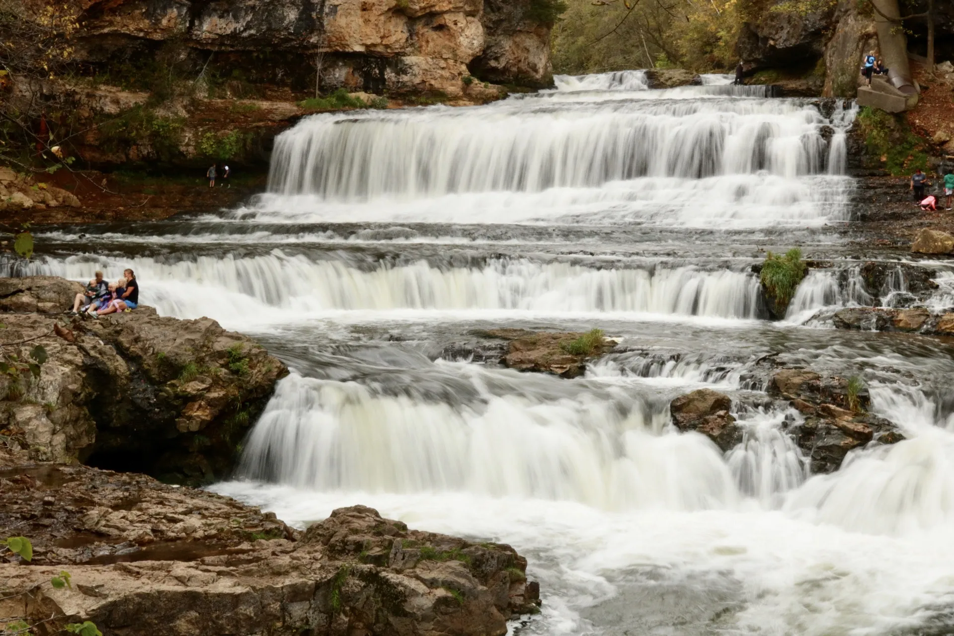This image is of Willow River State Park. As seen in the photo held above; the first day of fall. A photo of their family aside a looming river and forest.
