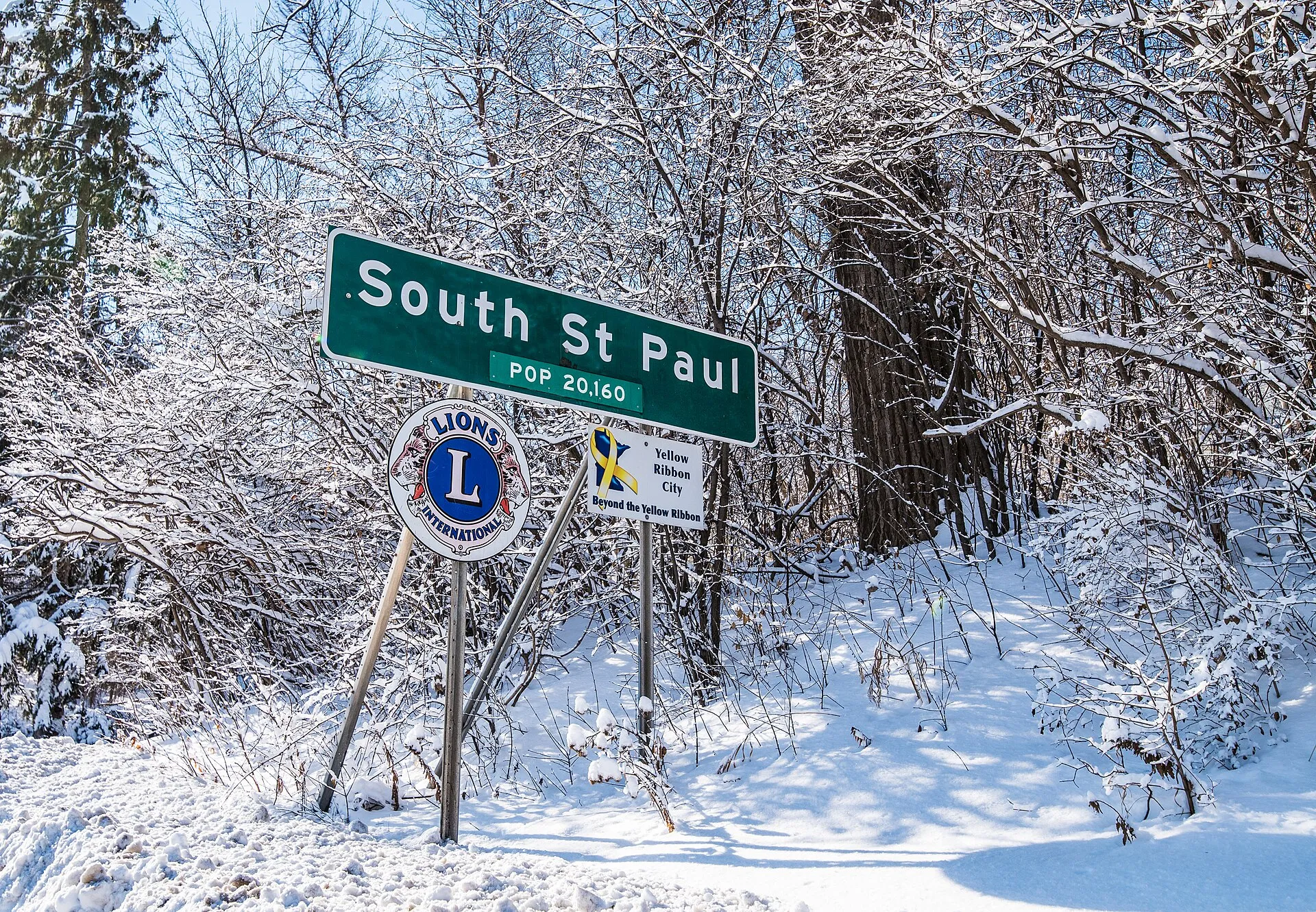 The population welcome sign for the City of South Saint Paul, Minnesota. Population 20,160 - Lions International sign - Yellow Ribbon City sign.
