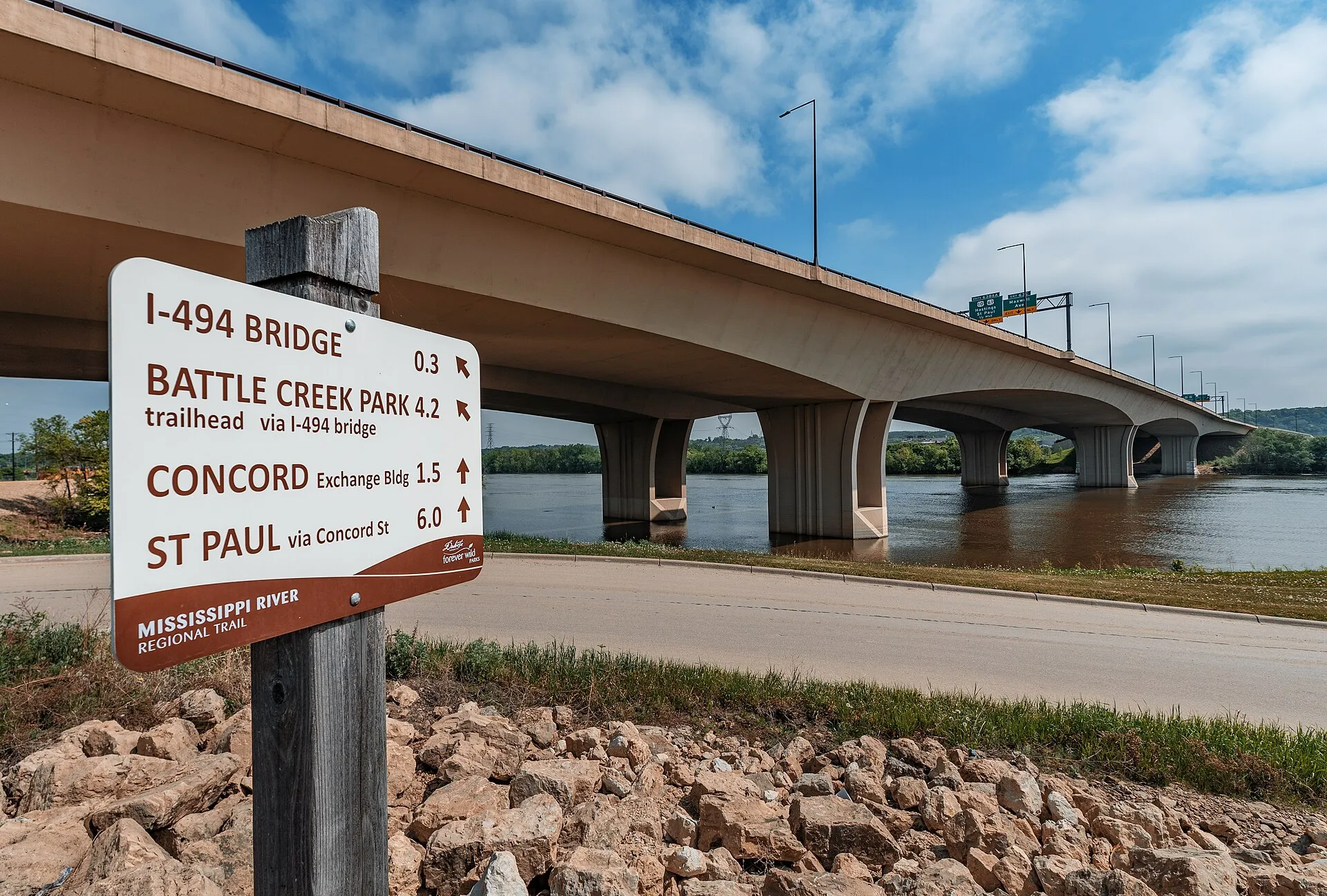 A directional sign on the Mississippi River Regional Trail next to the Wakota Bridge (I-494), in South St. Paul, Minnesota, on a spring afternoon.
