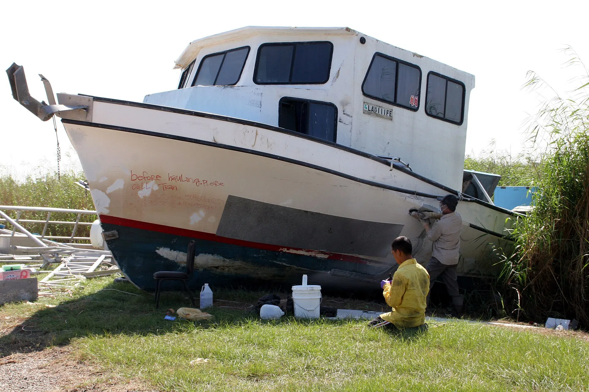 Local fishermen repair a boat damaged by Hurricane Katrina, Empire, Louisiana, October 2005