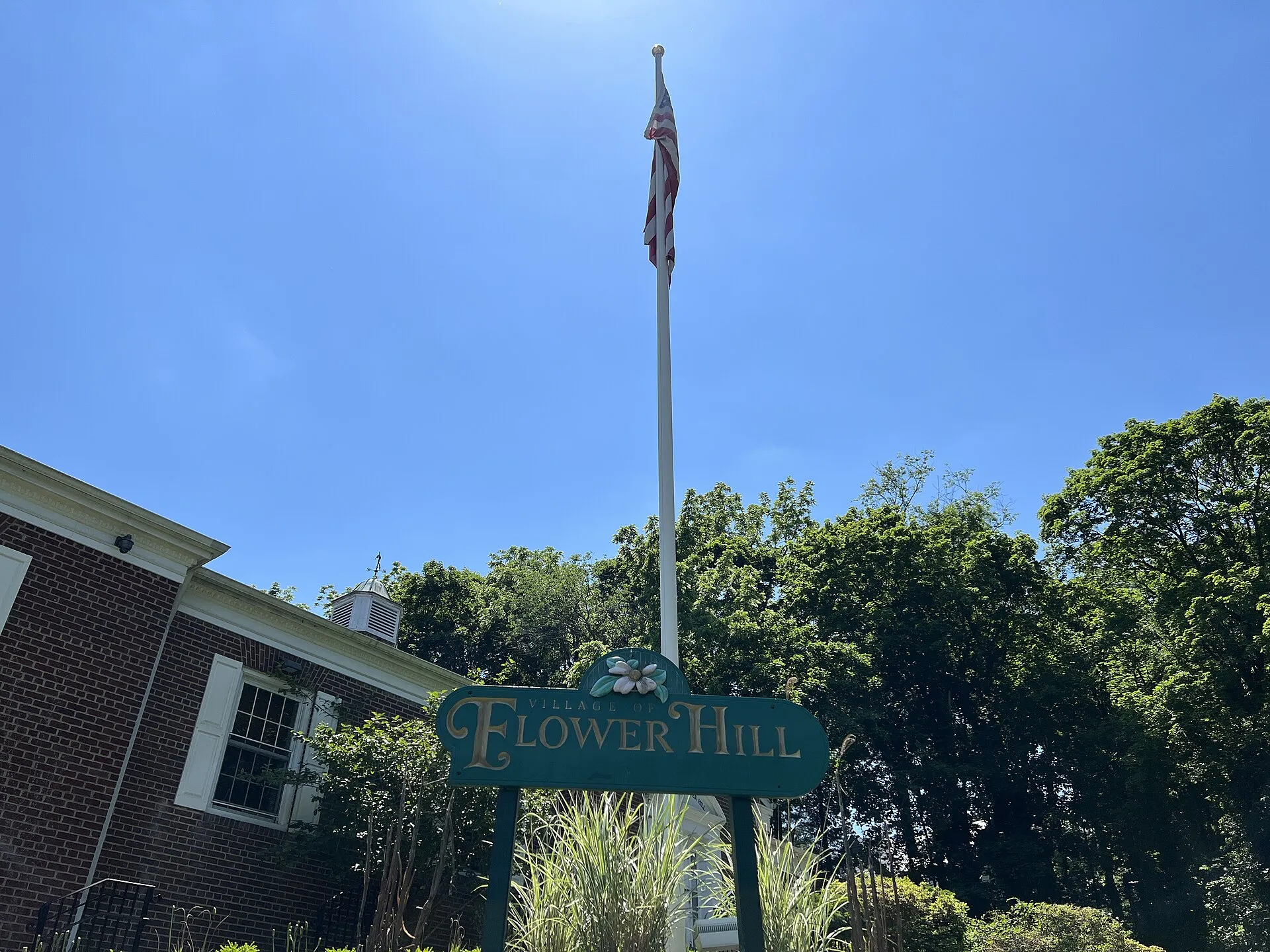 Flower Hill Village Hall and the American Flag in the garden in front of it in the Incorporated Village of Flower Hill, Long Island, New York, as seen on June 4, 2022