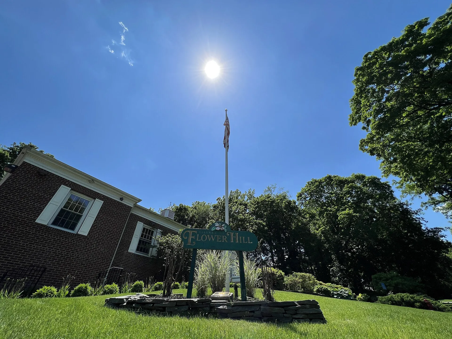 Flower Hill Village Hall and the American Flag in the garden in front of it in the Incorporated Village of Flower Hill, Long Island, New York, as seen on June 4, 2022